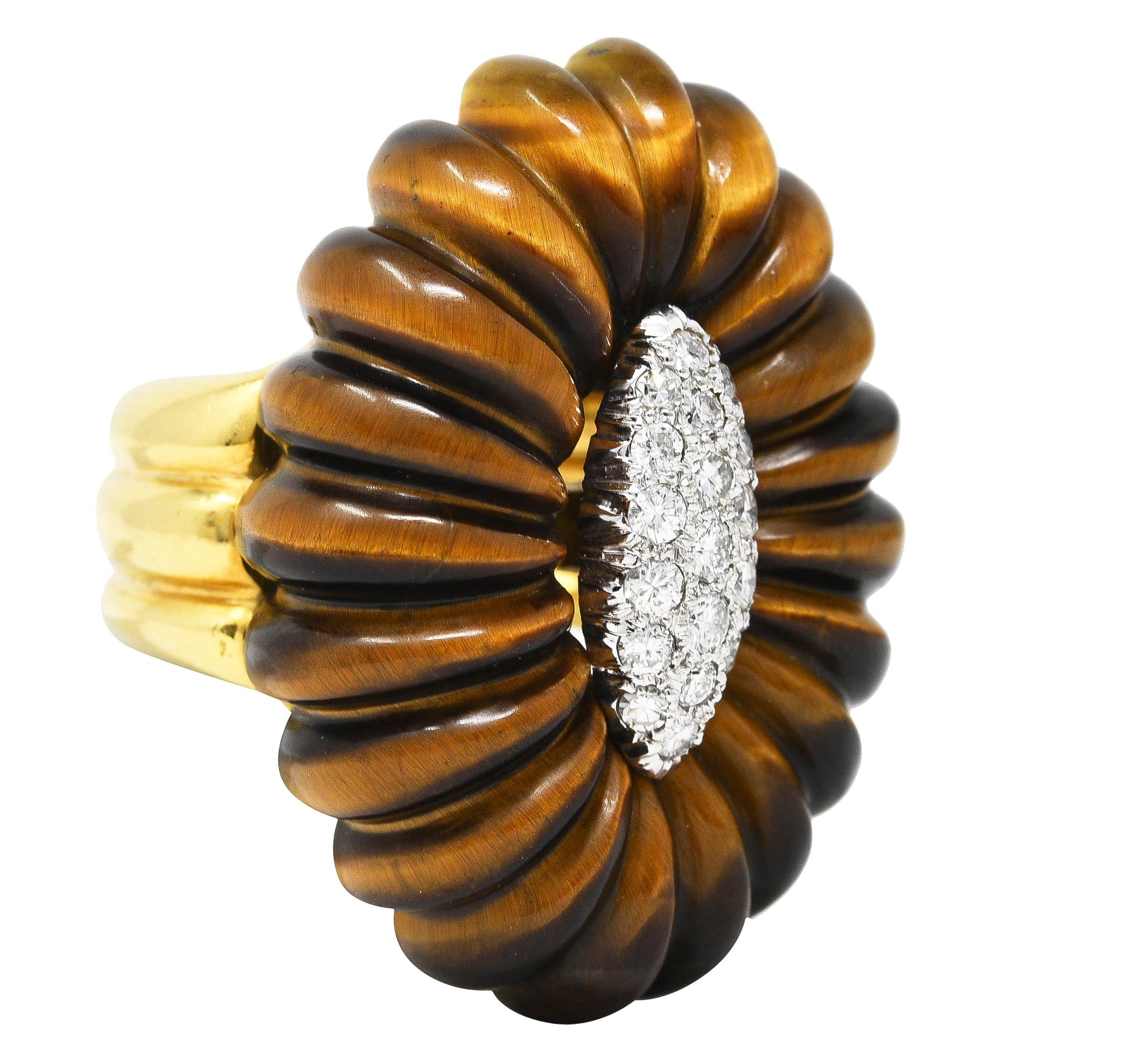 Centering round brilliant cut diamonds pave set in a navette shaped white gold form. Weighing approximately 0.54 carat total - G/H color with VS2 clarity/ Accented by a surround of carved tiger's eye quartz fluting. Opaque brown to yellowish orange