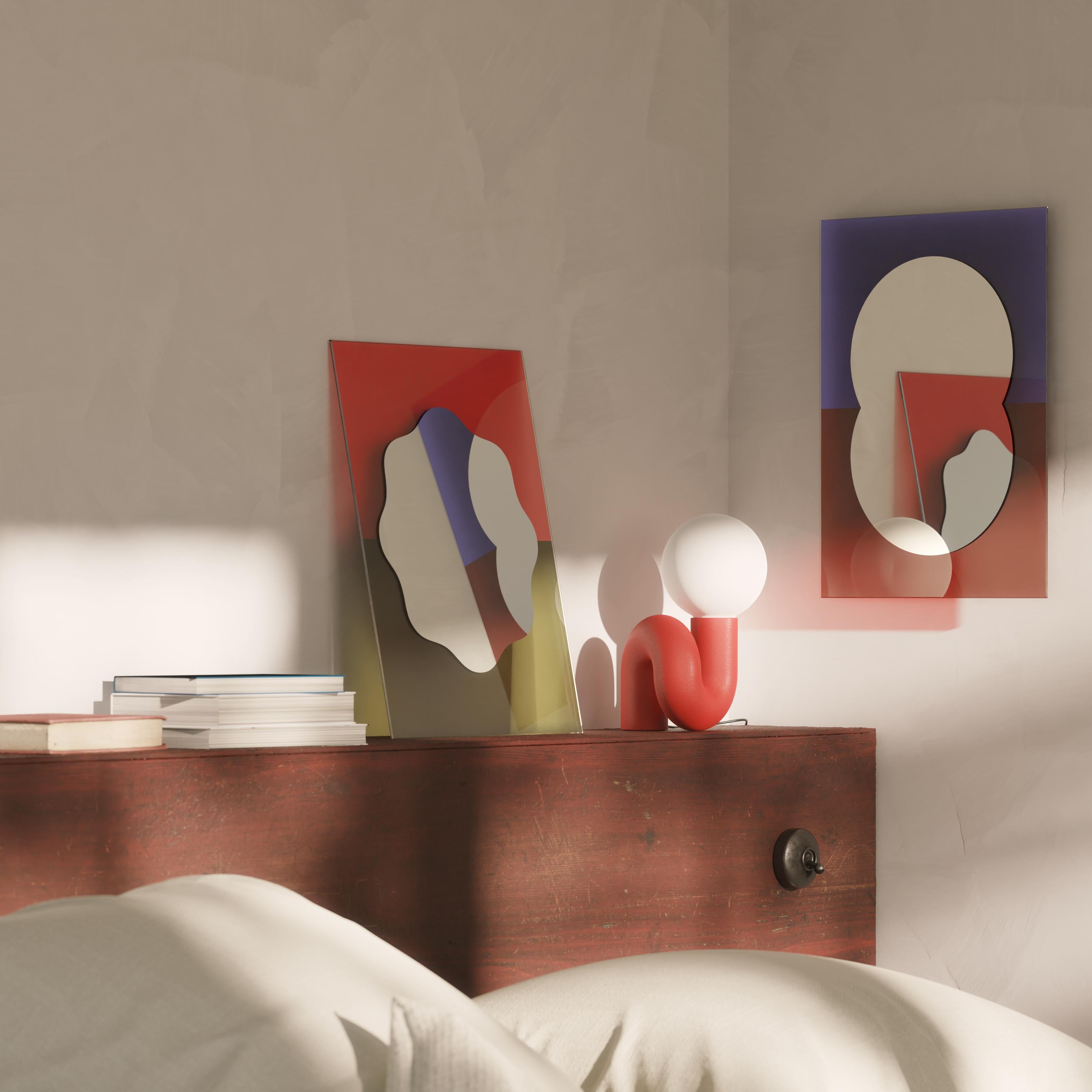 The Small Wander Mirror was inspired by the arts of painting and collage by playfully using shapes and colors to create a bright and dynamic look. The rounded mirror is backed by a translucent colored glass panel, which will cast a subtle halo on