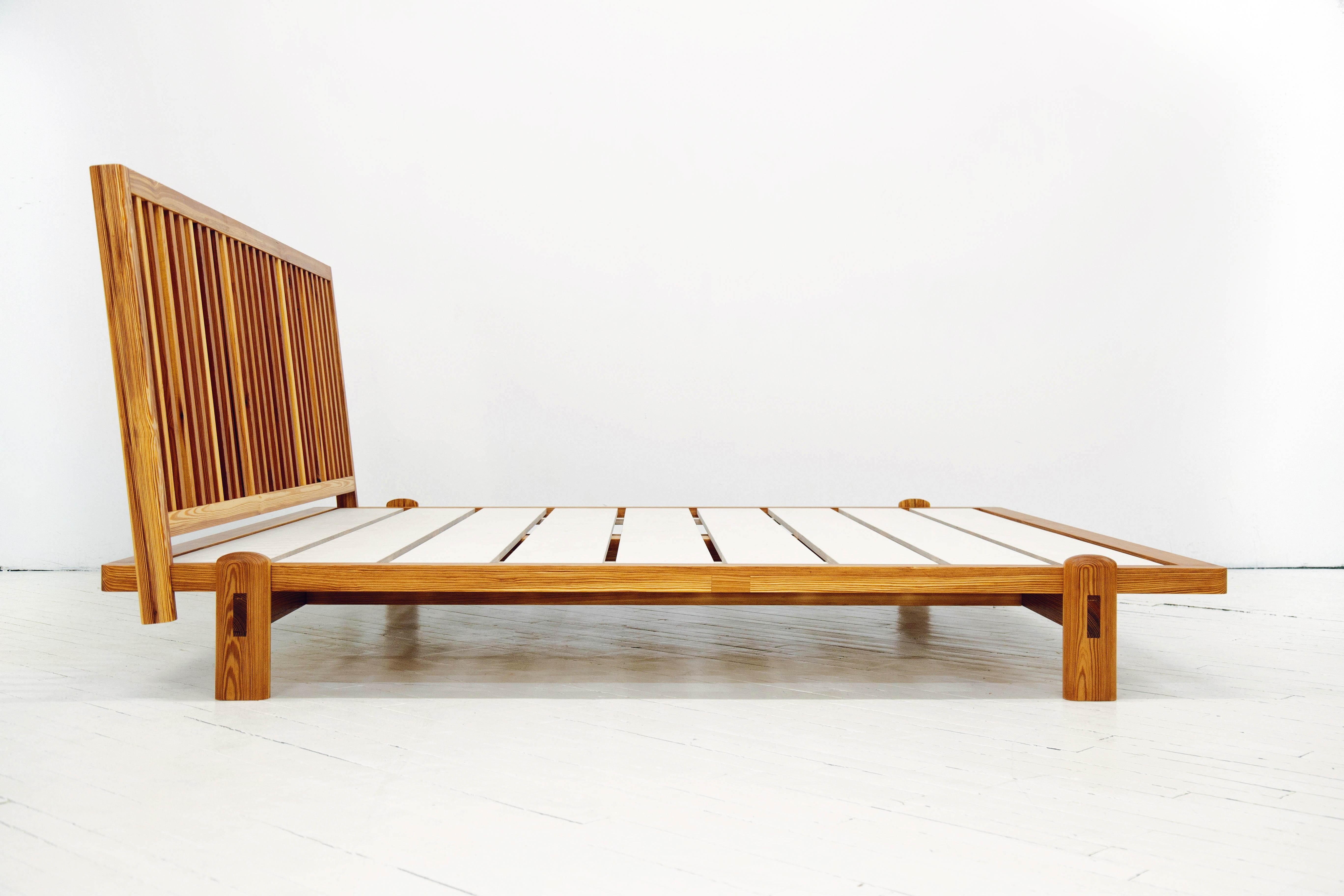 Basándonos en varias inspiraciones, diseñamos esta cama pensando en lo que querríamos en nuestra casa.  Un sencillo armazón de plataforma descansa sobre una robusta base con la clásica carpintería de espiga en cuña.  El cabecero de láminas está en