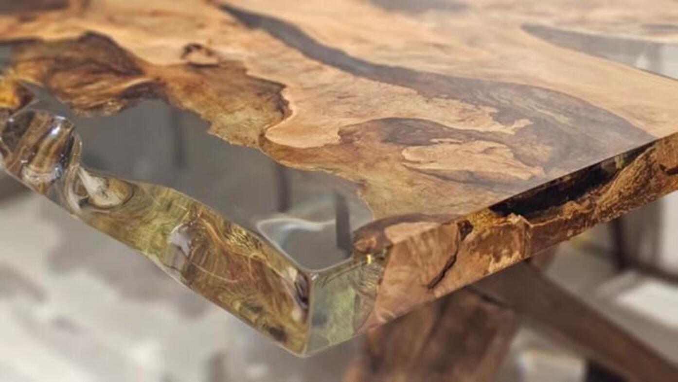 Dieser Esstisch verbindet die Textur der Natur mit modernem Design, mit einer lebhaften Holzoberfläche und einem klaren Harzdetail, das die Blicke auf sich zieht. Die natürlichen Muster und warmen Töne des Holzes kontrastieren mit der Klarheit des