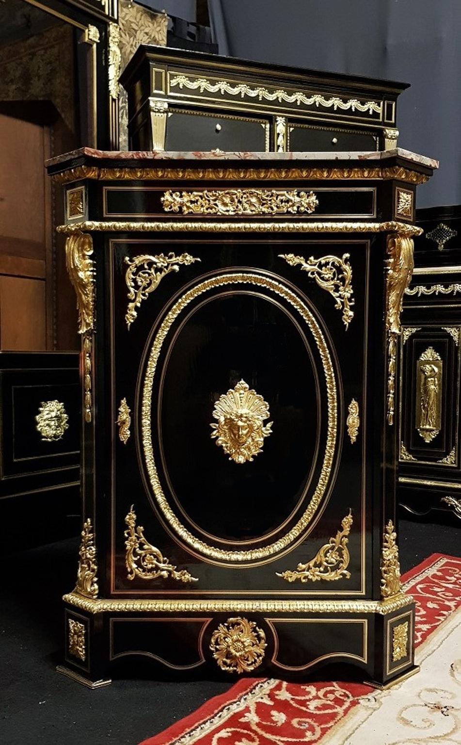 Unique cabinet in Boulle Marquetry with brass filets and rich and important ornementations in gilt bronze.
On the door you will find a beautiful bronze mask representing the Greek Goddess of War Minerva.
The interior parts are in mahogany with