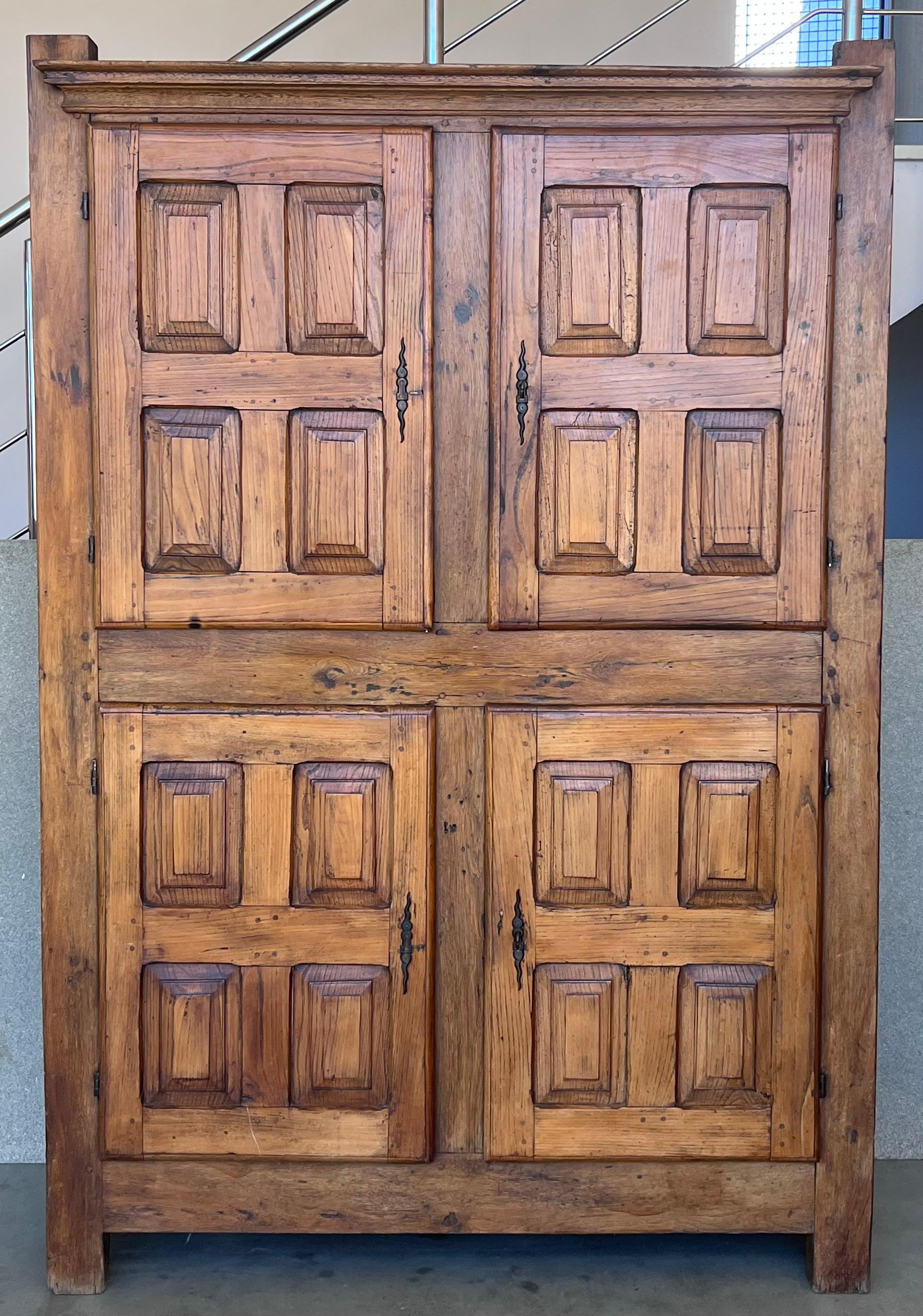 Exquisite 18th century Spanish armario or wardrobe armoire constructed from walnut. Features a coffered case fronted by four large doors. This massive cabinet made in Spain features beautiful walnut grain and showcases the amazing craftsmanship.