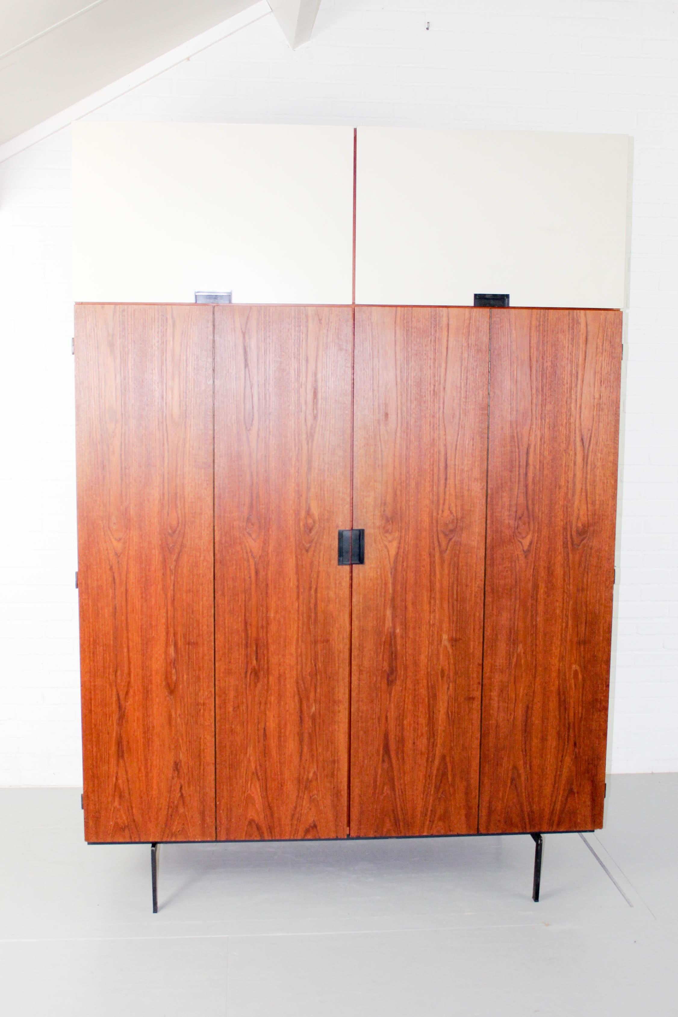 Wardrobe KU15 Cees Braakman Pastoe Japanese series 1960s. It has two doors in teak with an additional folding mechanism, revealing four storage spaces. Iconic square black metal handles make it a piece of very recognizable Japanese series.
 
   