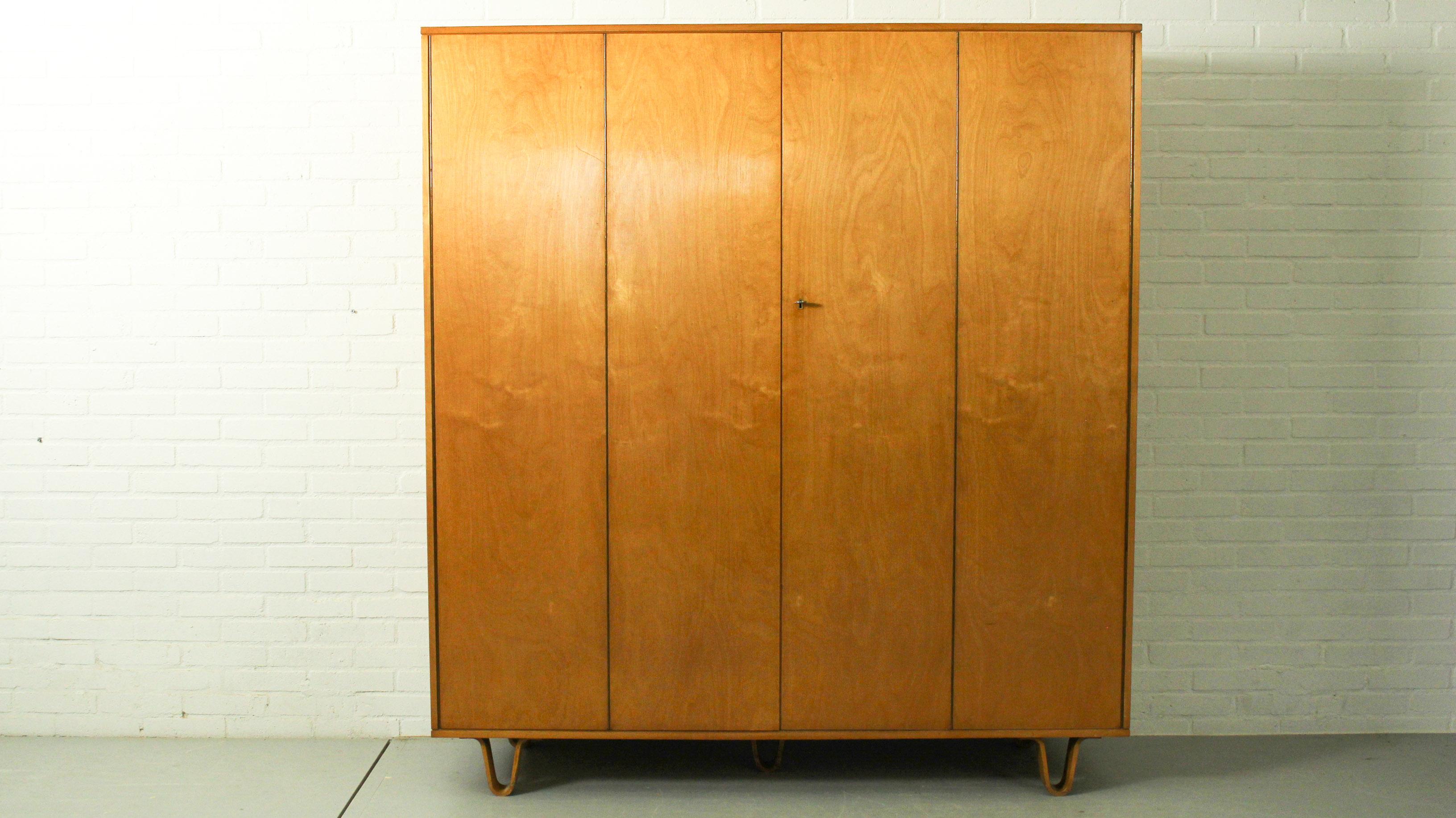 Large cabinet (KB04) made by Cees Braakman for Pastoe. This cabinet has two folding doors, behind the doors shelves are hidden, with original bentwood drawer and bentwood box attached to door. Makers stamp and notes on backside. This cabinet