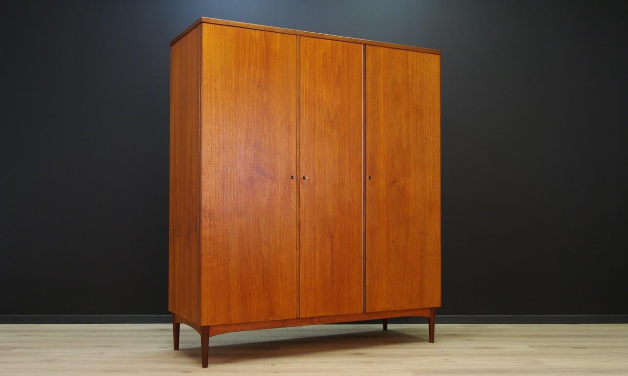 Fantastic wardrobe from the 1960s-1970s, minimalistic form, Danish design. Surface covered with teak veneer. Roomy interior with hangers. In the left section, three drawers and a mirror, in the middle, two shelves. The key in the set. Preserved in