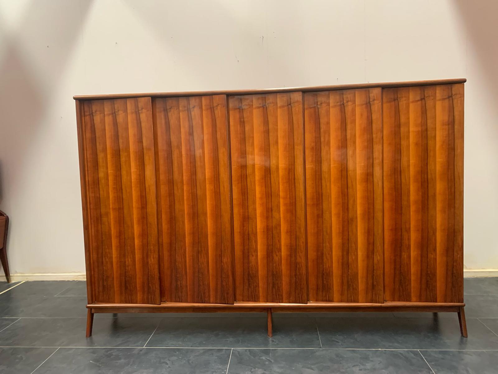 1960s Wardrobe of exceptional design. The excellently built structure with generous thicknesses guarantees functionality and solidity. The central body features a selection of rosewood doors placed diagonally without visible hinges and handles. The
