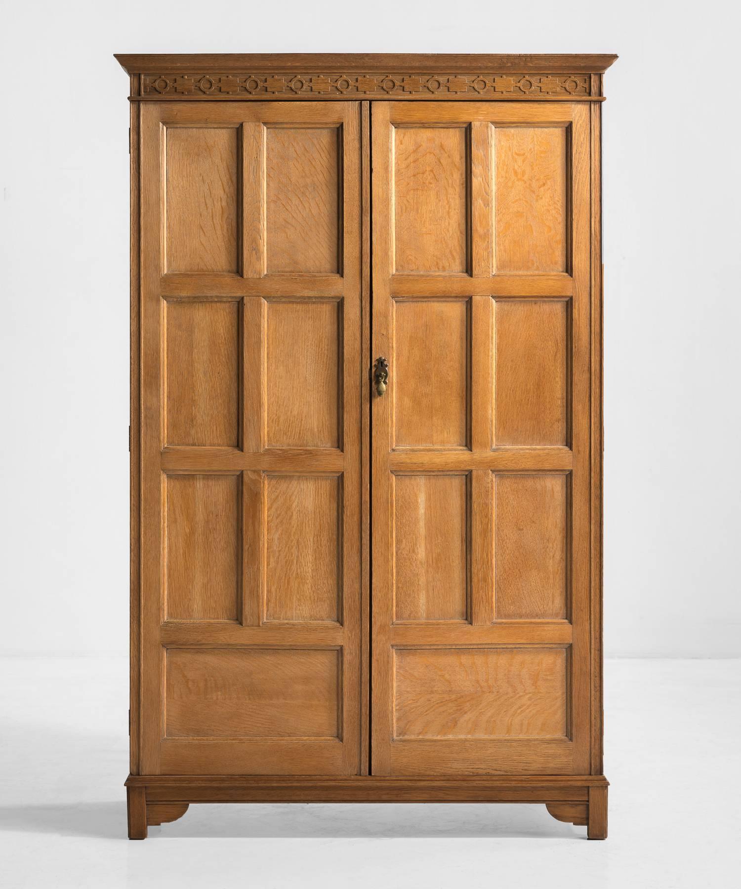 Solid oak double wardrobe with panelled doors. Inside is a large hanging space with central brass hanging bar with hooks.