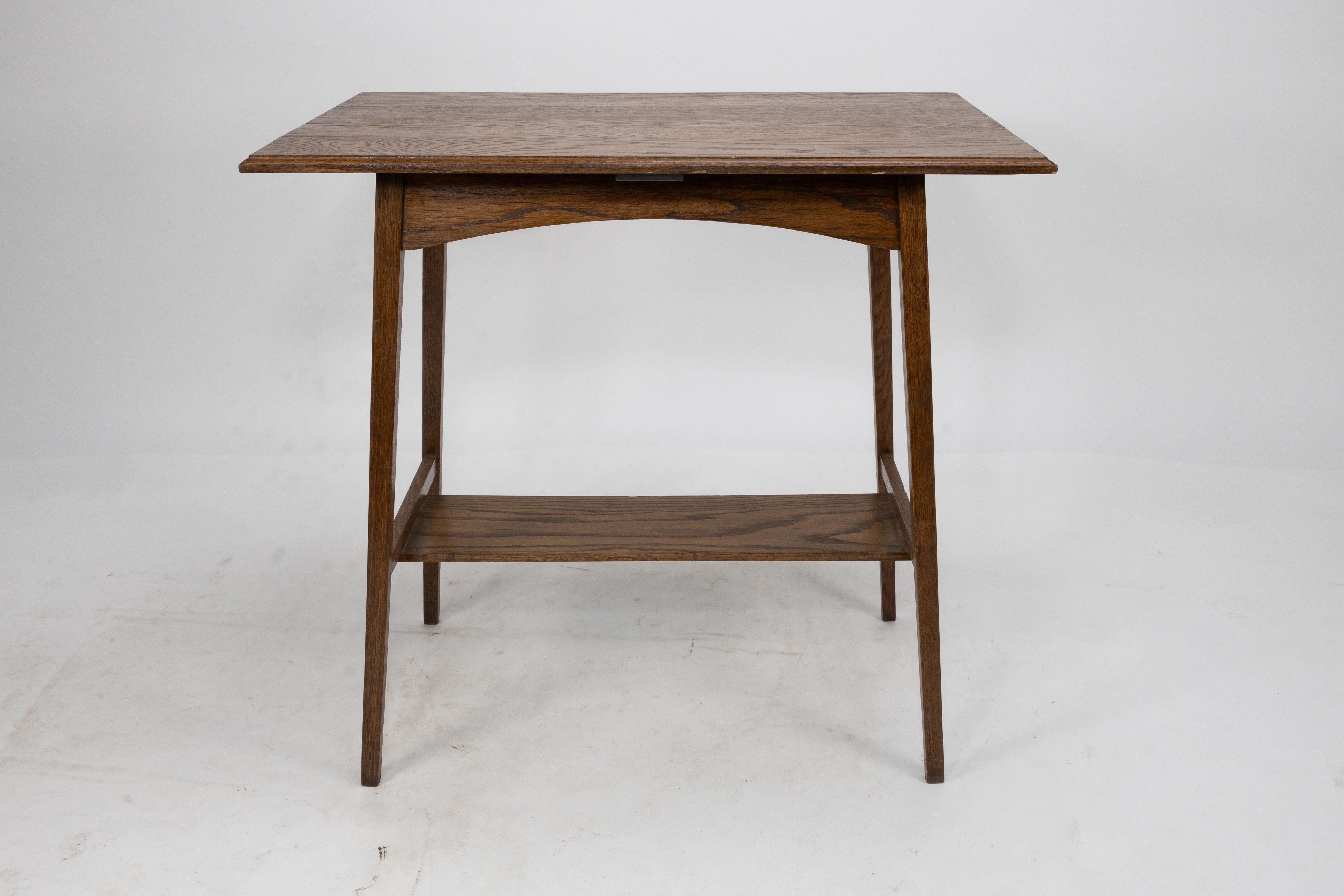 Waring and Gillow. A pair of Arts and Crafts side tables with oblong tops and curved aprons below stood on slender tapering legs united by stretchers and a lower shelf.