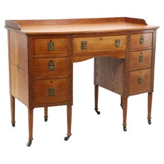 Waring & Gillow. Escritorio Arts and Crafts de doble cajonera, con frontal de arco y rodillera