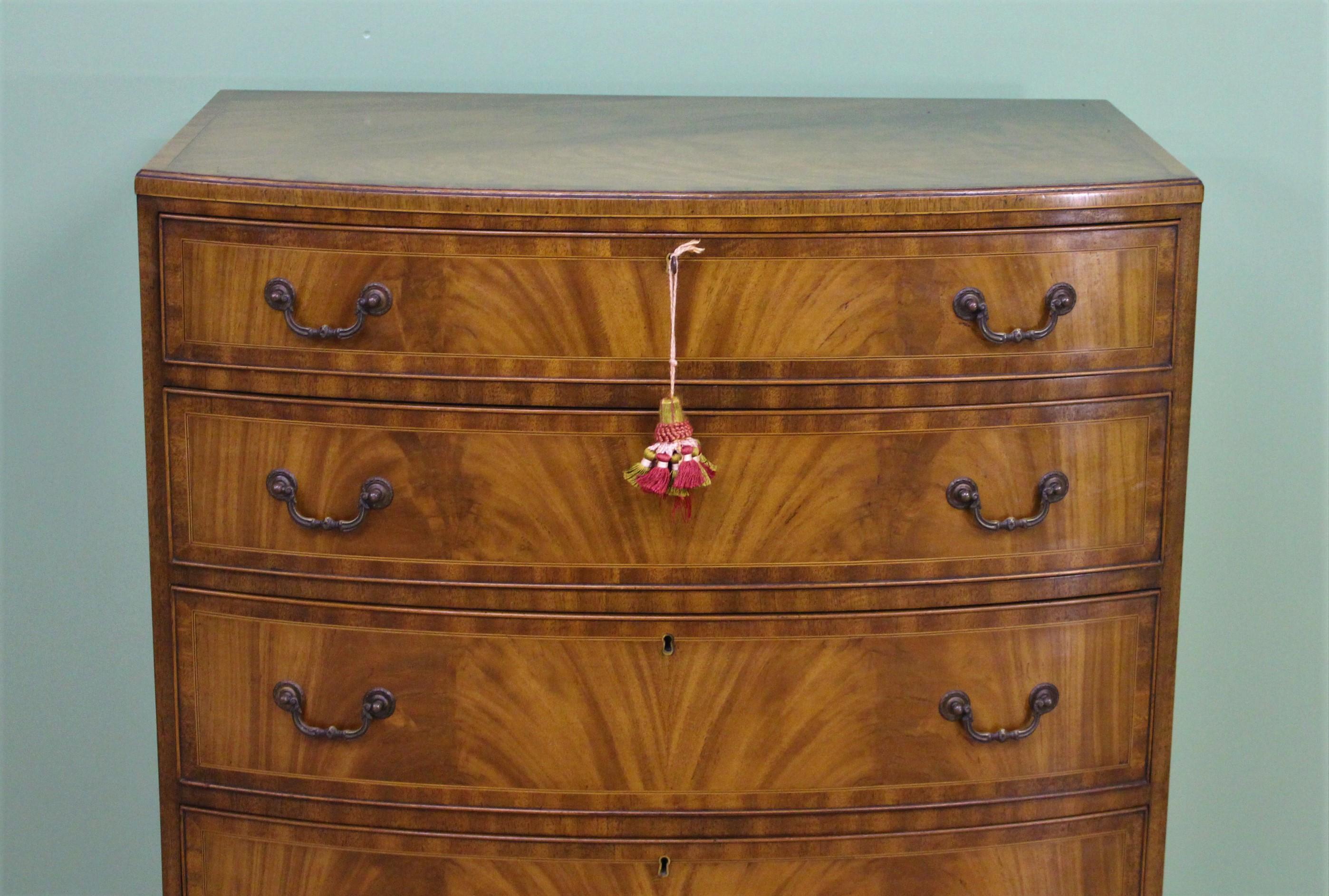 A lovely inlaid flame mahogany chest of drawers by Waring and Gillow. Of bow fronted from and of excellent construction in solid mahogany with attractive flame mahogany veneers. The chest top and drawer fronts are all cross banded. There is an