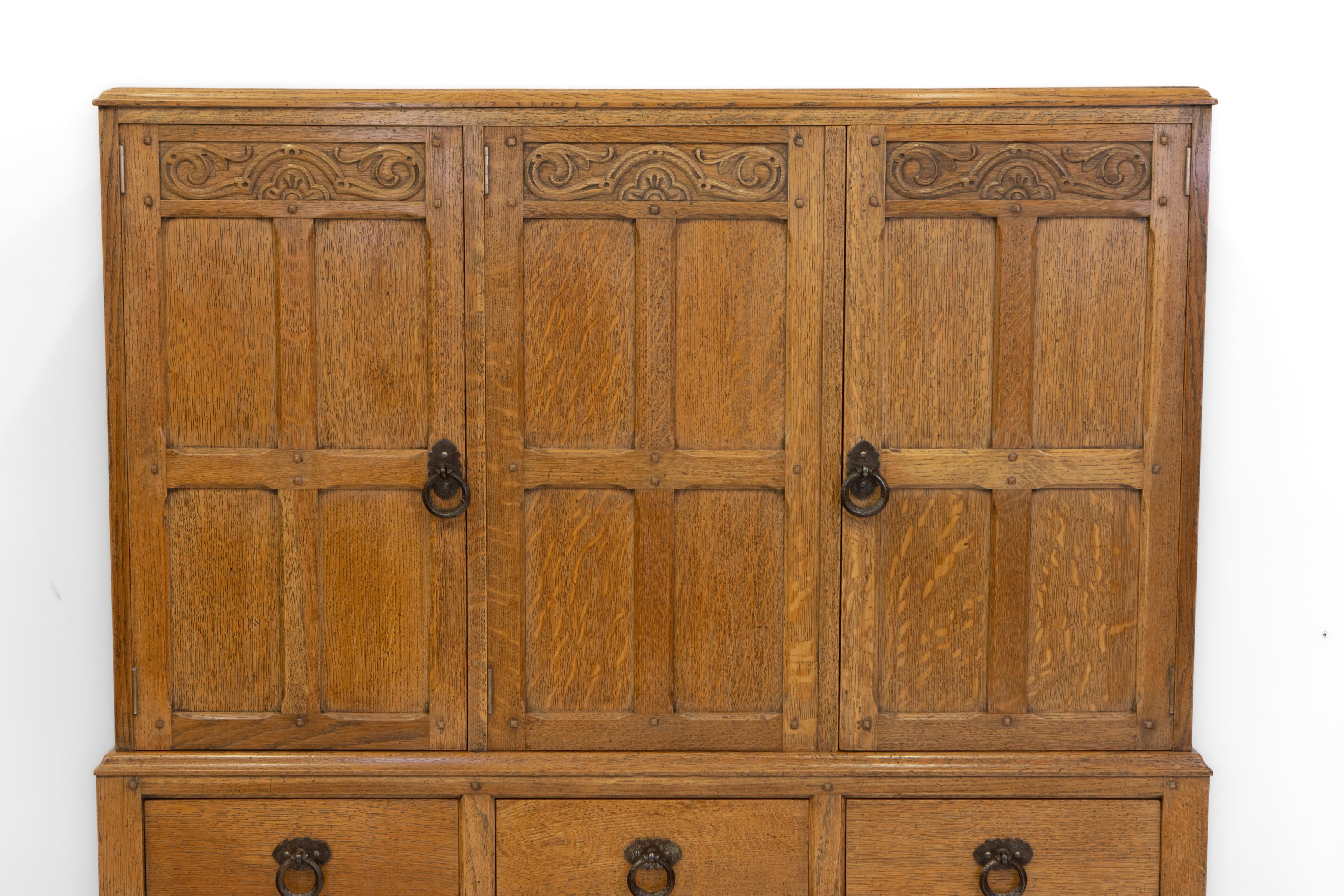 Superb Waring & Gillow oak Arts & Crafts/Cotswold School manner cabinet on stand. Circa 1920. Maker's stamp. 

Excellent quality, made in solid oak with chamfered edge detail to the stand and cupboard doors, and peg construction. Hand hammered