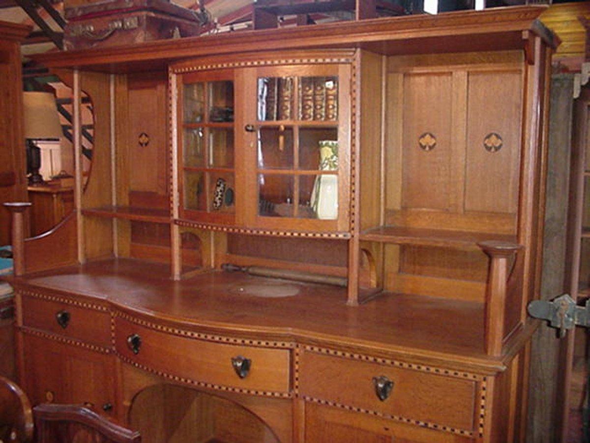 Waring and Gillows, in the style of M.H. Baillie Scott.  a chequer, ebony and boxwood inlaid oak sideboard, in the manner of M.H. Baillie Scott, with makers metal label. 
Under close inspection of the label it says 'Waring and Gillow', the 'Gillow'