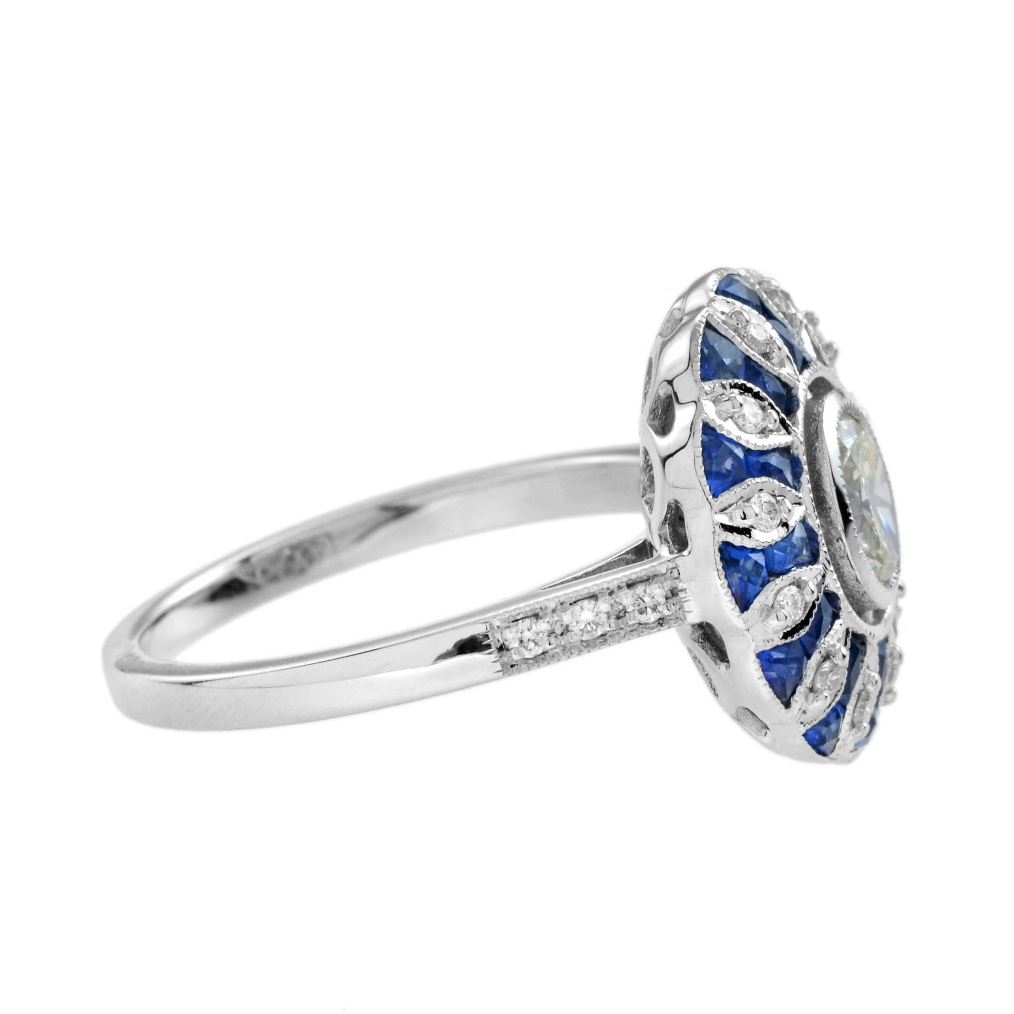 This gorgeous ring showcases a bezel set oval diamond surrounded by twenty-four French cut blue sapphires and eight-teen diamonds with additional diamonds on the shoulders. Pierced details and milgrain throughout the ring add to a breathtaking
