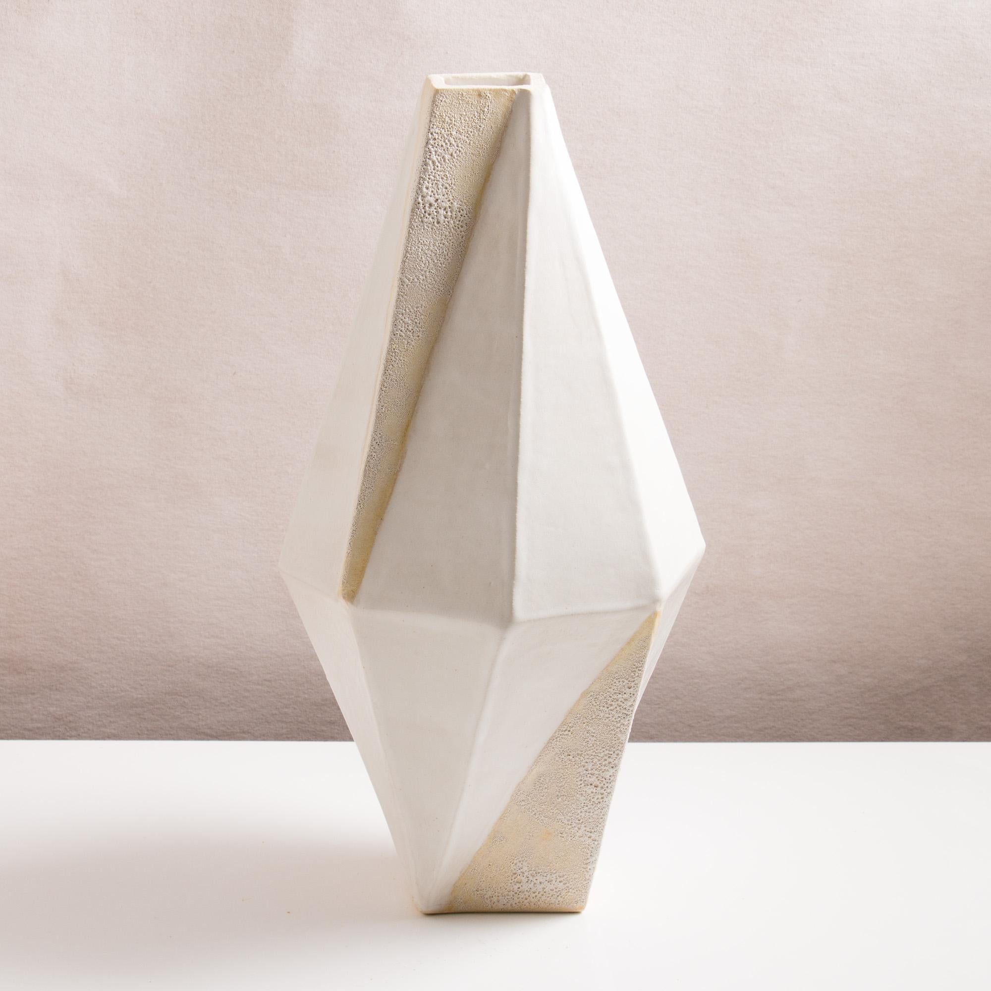 This large one-of-a-kind ceramic vase combines complex geometric lines with the warmth and individuality inherent in handmade work. It was assembled from flat sheets of a white stoneware, into a geometric shape that feels both natural and entirely