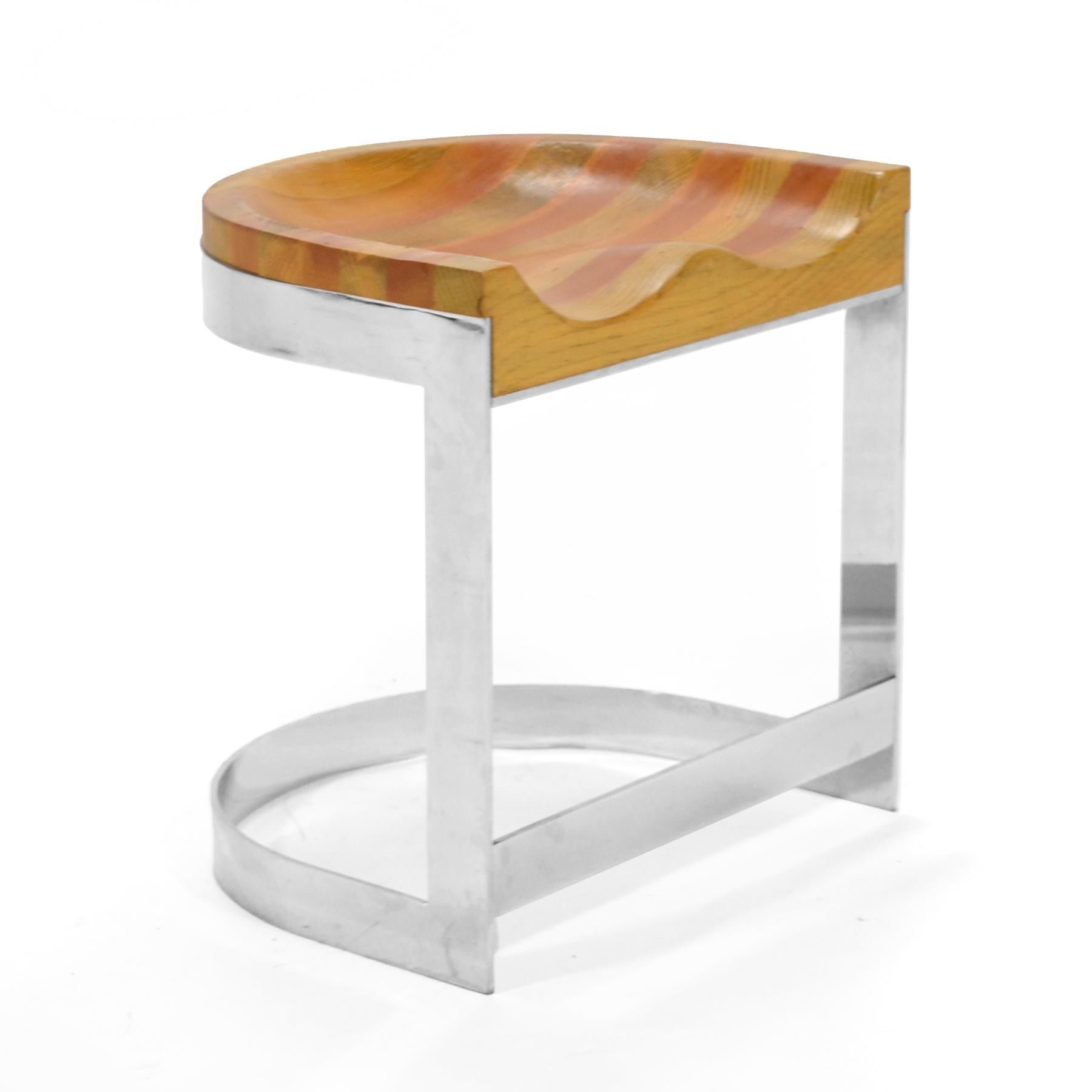 This beautiful design by Warren Bacon rocks! It combines a thick sculpted oak seat with a polished chrome steel base. The warm, organically shaped seat contrasts wonderfully with the cool, linear steel.