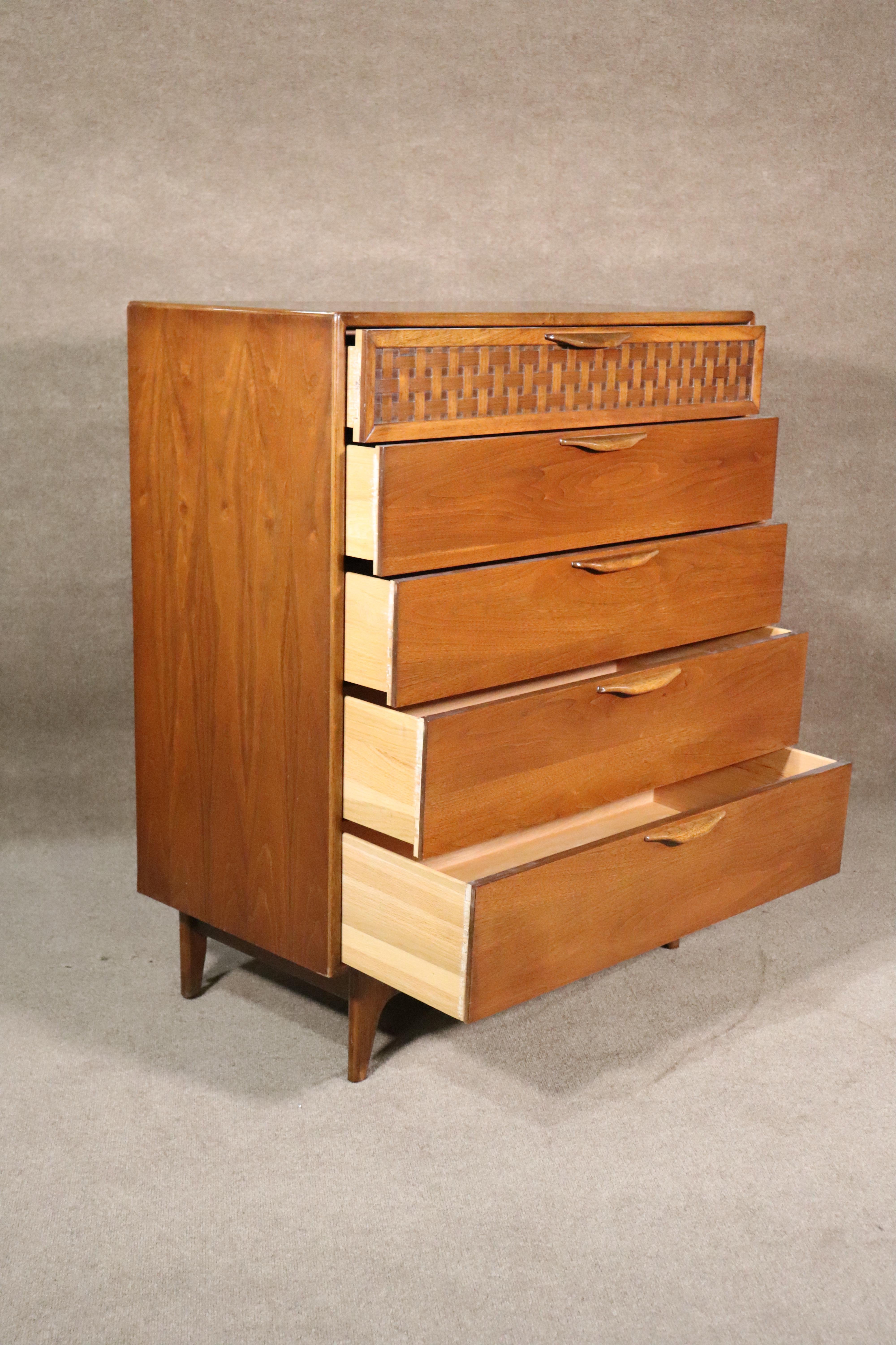 Tall chest of drawers with warm walnut grain and woven front. Designed by Warren Church for his 