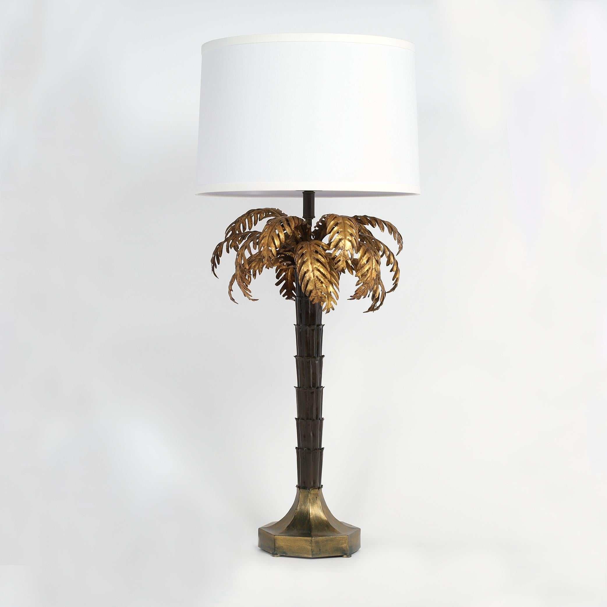 Chic mid century pair of sculptural palm tree table lamps crafted in metal with aged gilt palm fronds over a trunk with a dark faux patina set in an octagon base with a bronze like finish on button feet.