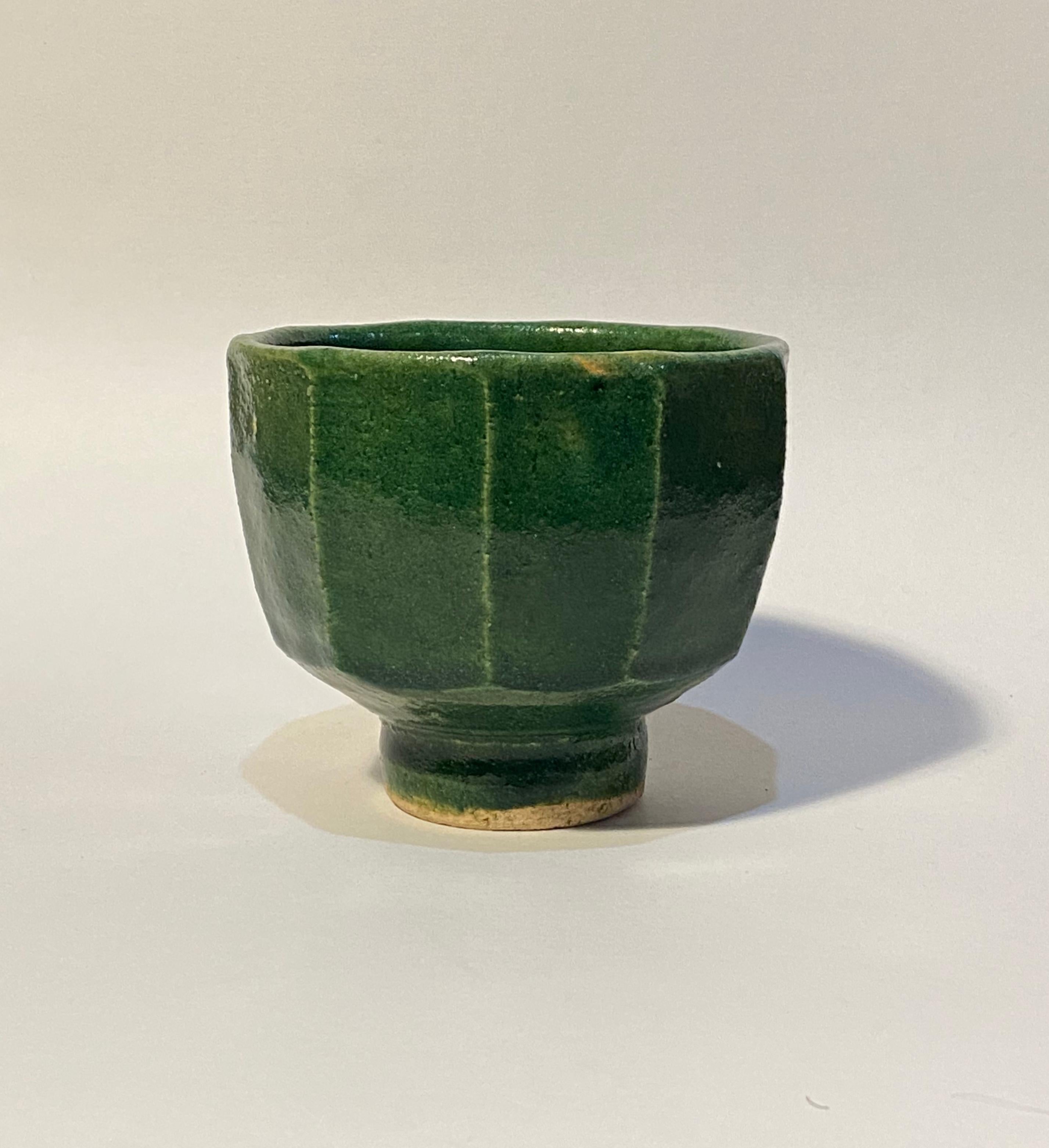 Warren MacKenzie (1924-2018)
Green faceted bowl, n.d.
Stoneware
4 1/4 x 4 7/8 inches
Not stamped

Warren MacKenzie was born in 1924 in Kansas City, Missouri, and died in late 2018. He studied ceramics at an art school, but was dissatisfied