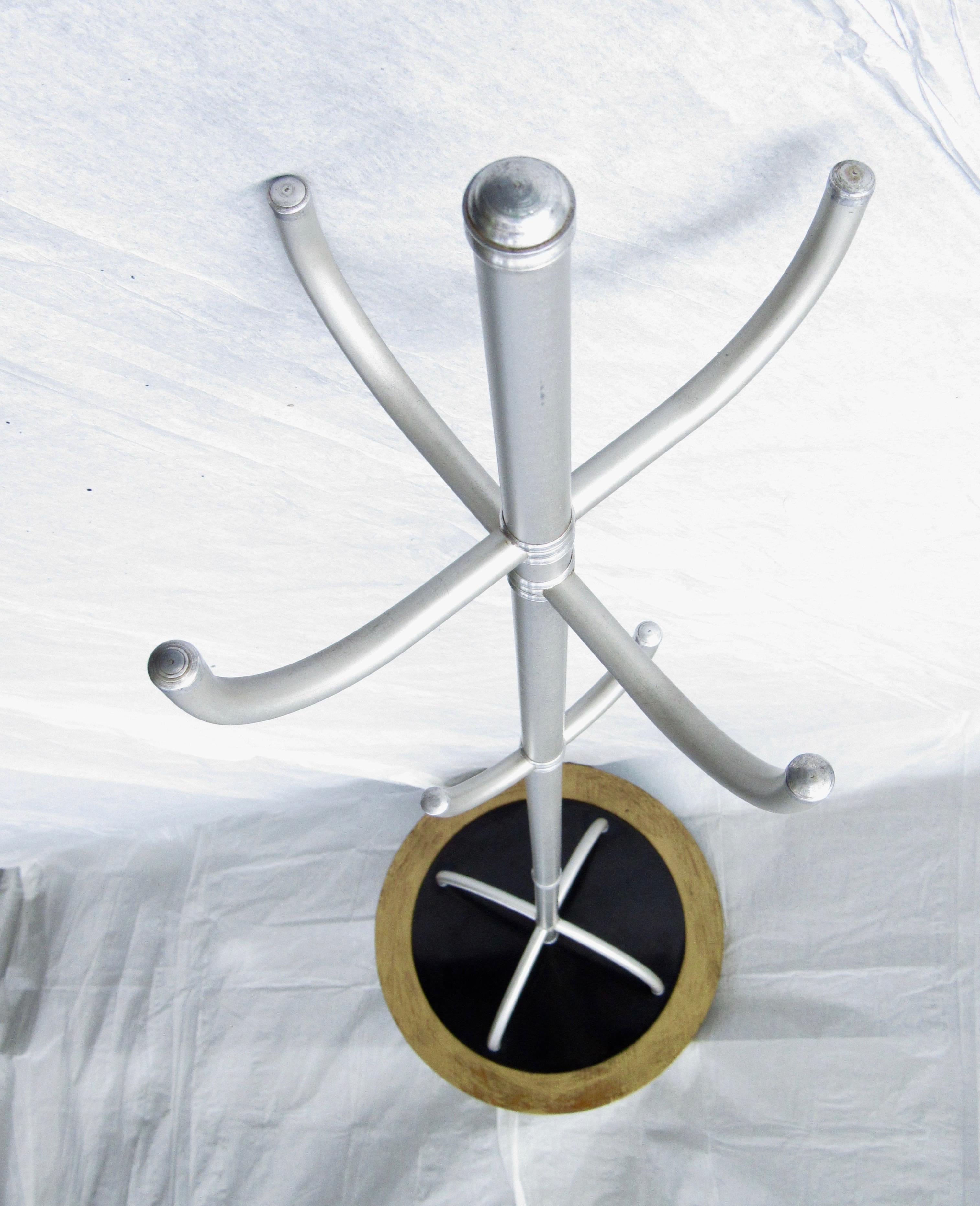 A Warren McArthur coat hat rack designed for the Arizona Biltmore and manufactured at the Warren McArthur Furniture Co. in Los Angeles, CA.
This is an early design with a center tube and 4 arched supports reflected in and attached to a black Formica