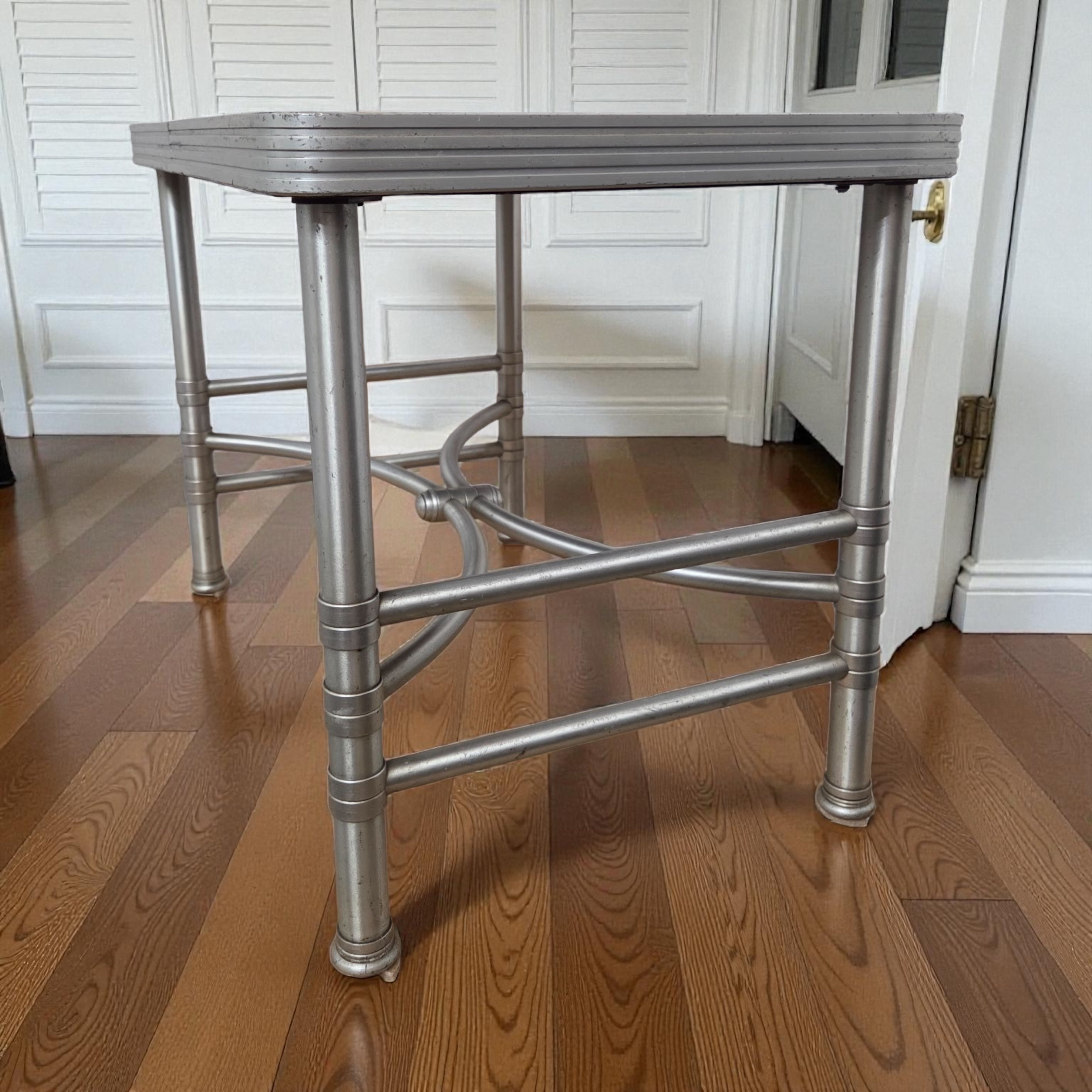 Cette table d'appoint Warren McArthur représente la période de production la plus sophistiquée du designer, entre 1936 et 1940. Dotée d'un plateau en Cafolite noir - une surface en résine phénolique appréciée pour sa durabilité et son caractère