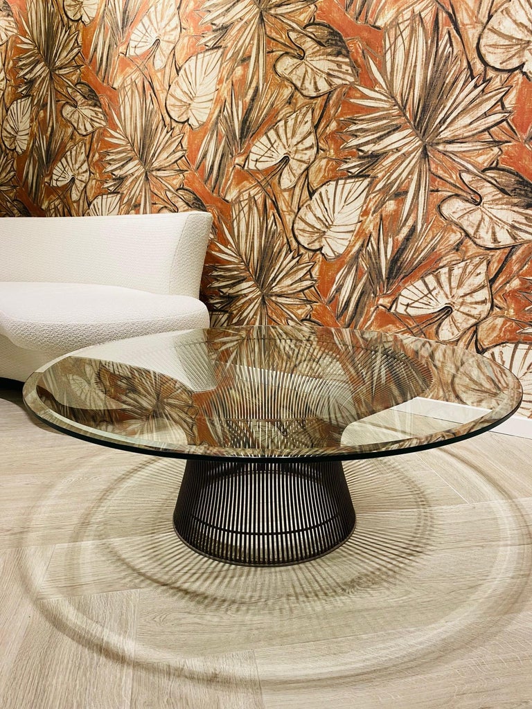 Iconic Mid-Century Modern coffee table by Warren Platner. Base comprised of steel wire rod construction with a metallic bronze coating. The table features a large 42” inch tempered glass top with beveled edges. This classic design mixes well with