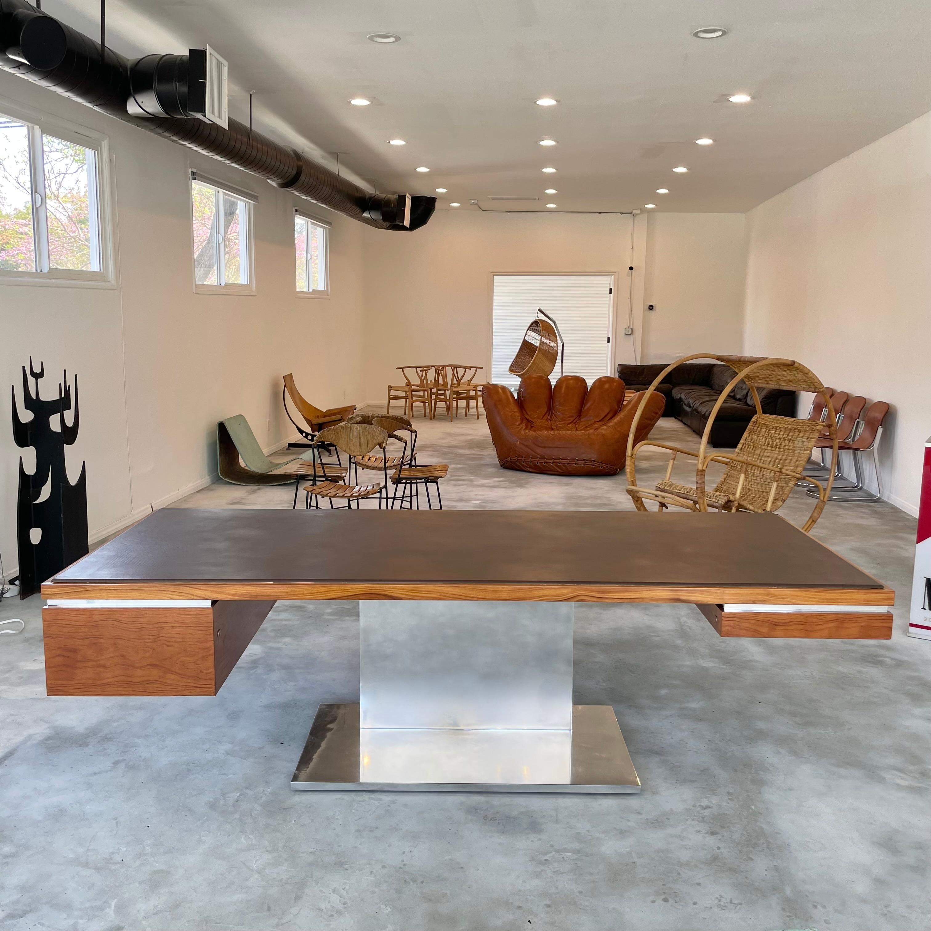 Stunning executive desk by American designer Warren Platner. Features an elegant Cherry Wood body floating atop a singular modern chrome pedestal base. Newly refinished.The desk top is covered in a chocolate leather giving this piece an incredibly