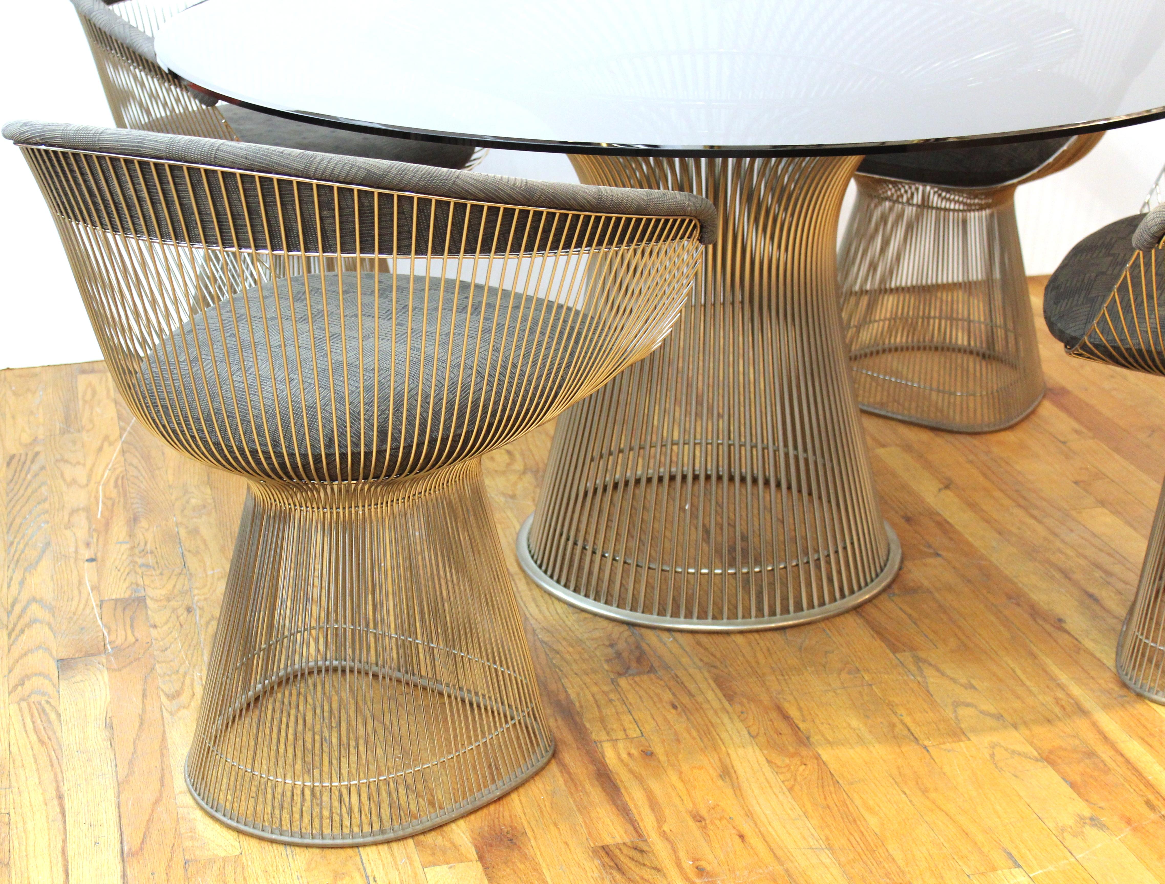 Warren Platner for Knoll Mid-Century Modern dining table with circular tinted glass top on chrome basket base, with four upholstered dining chairs.