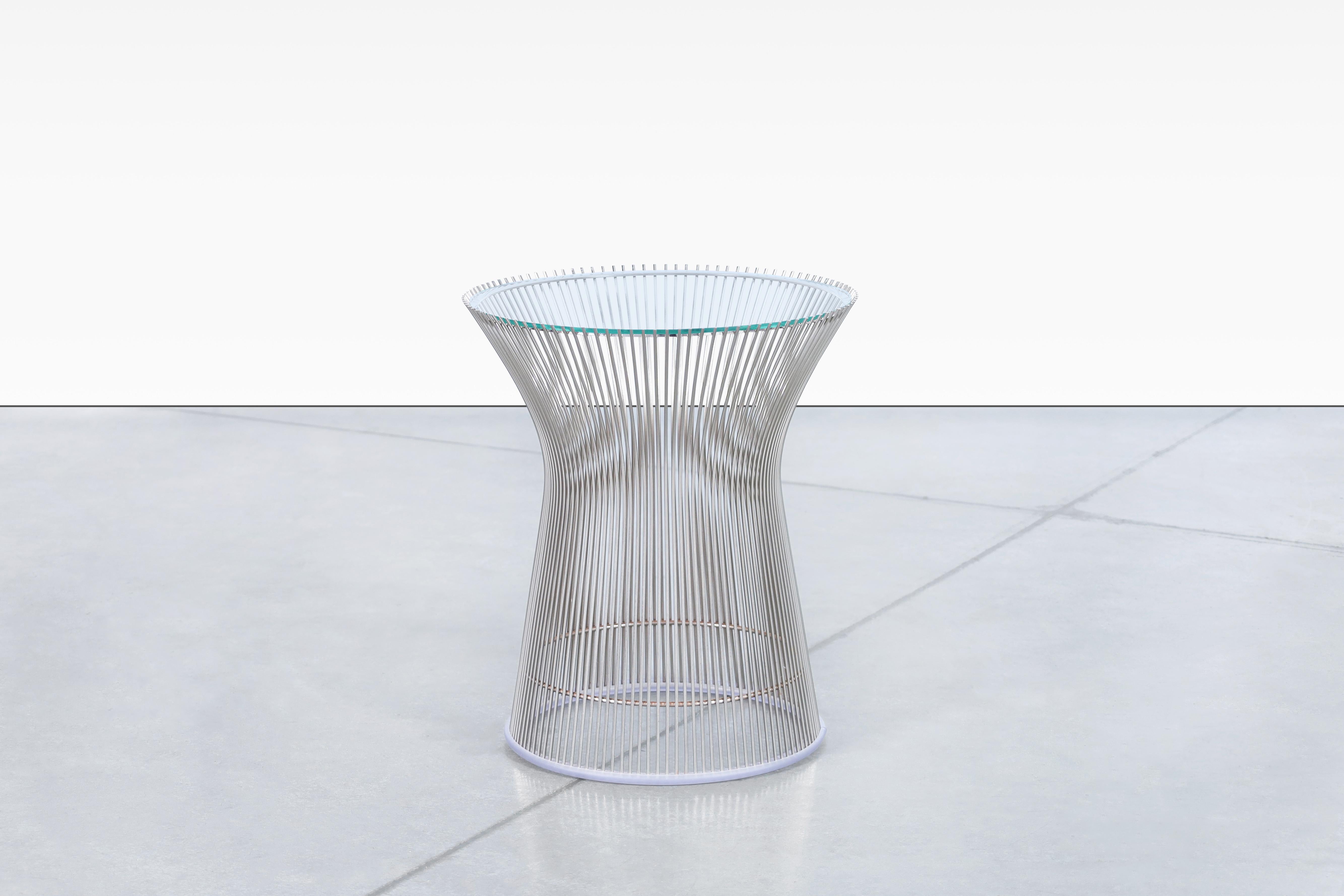 The polished nickel side table designed by Warren Platner and produced by Knoll is a stunning piece of furniture that is sure to impress. The table's intricate and eye-catching base is constructed with hundreds of curved steel rods that were