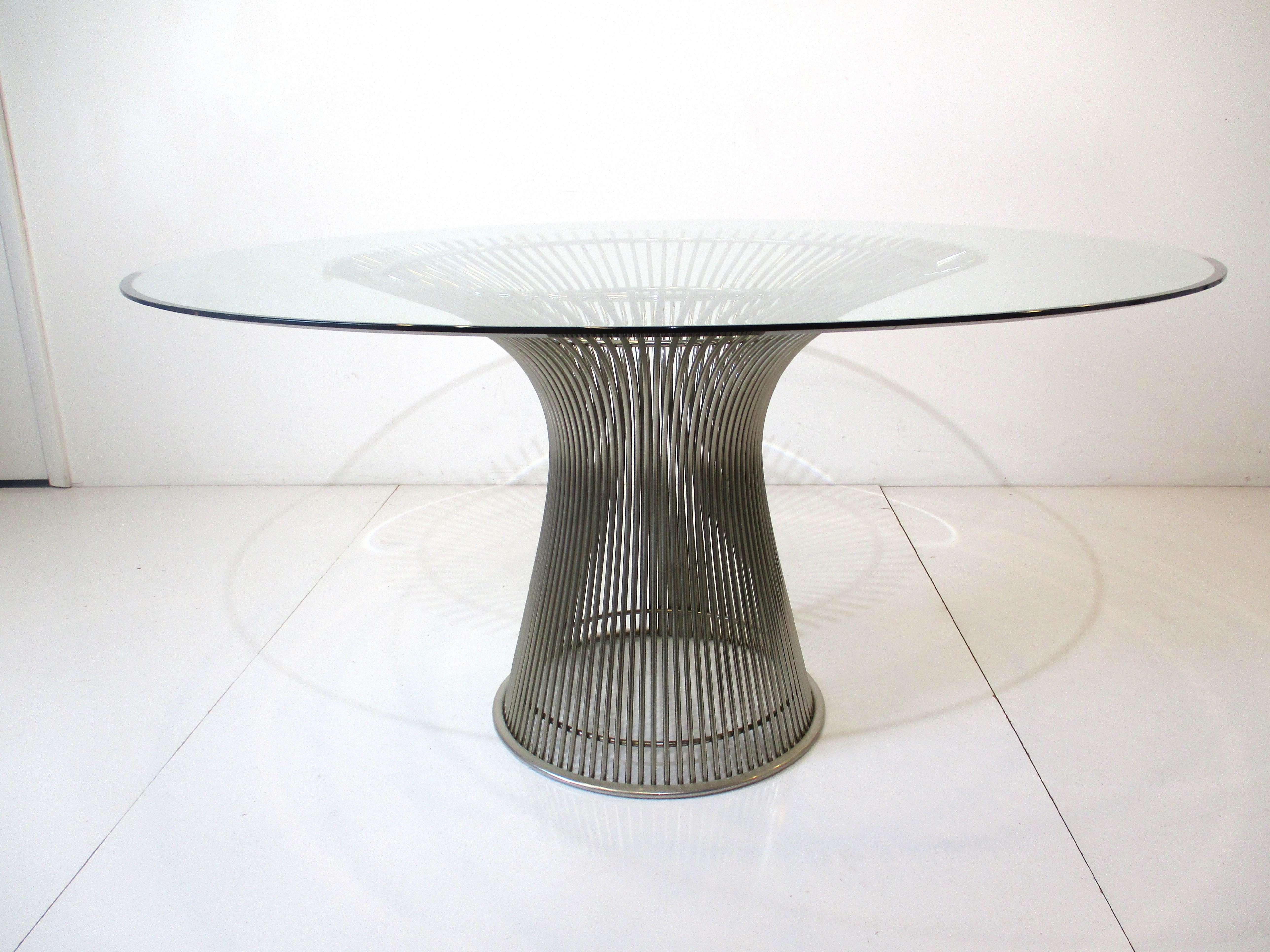 A very well crafted polished nickel plated welded vertical steel wire rod dining table with thick temped fine beveled edged glass top. Manufactured by Knoll International this vintage table has a clear plastic extrusion ring to it's base to protect