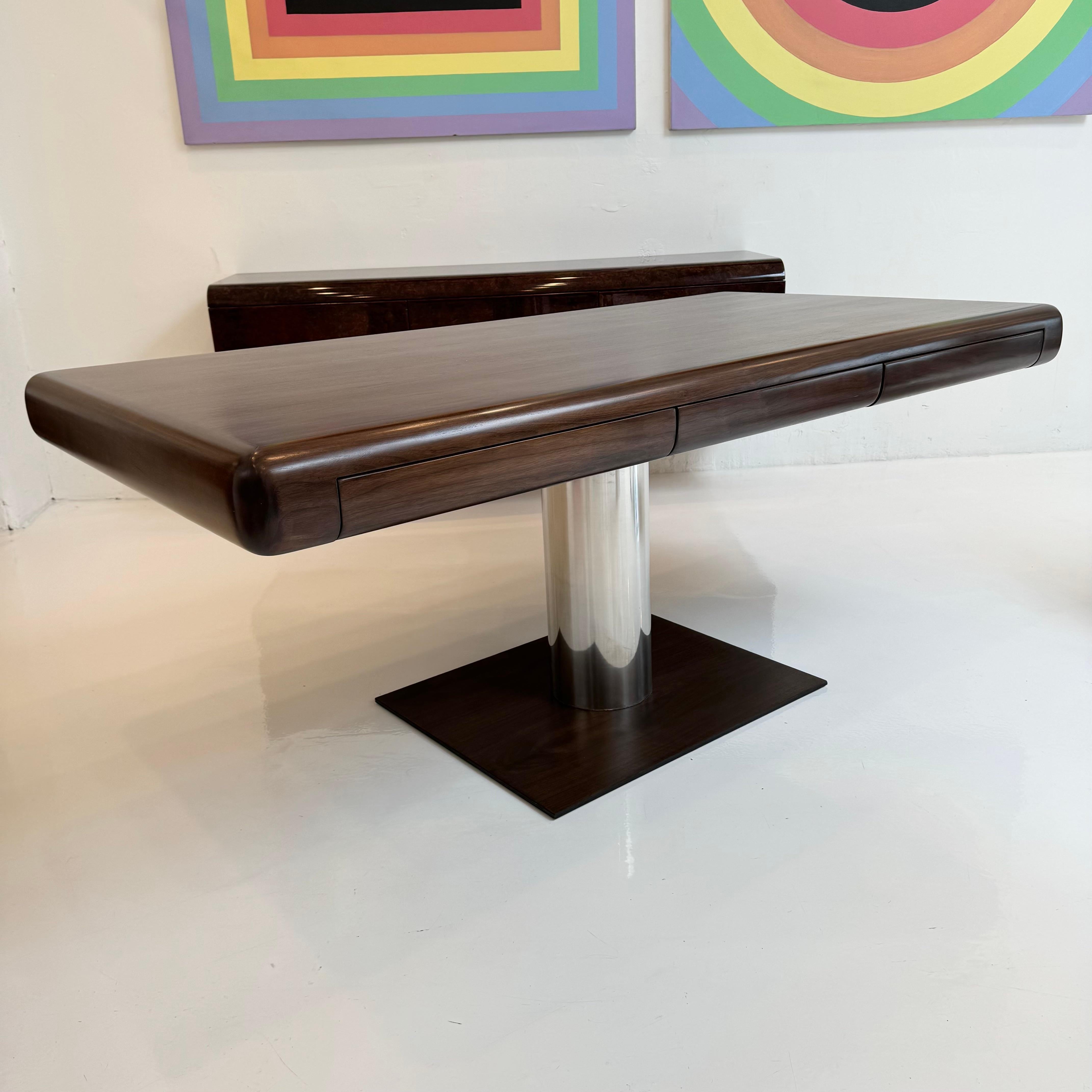 Stunning pedestal desk in the style of Warren Platner. Made of solid walnut,  newly refinished and in excellent condition. Elegant top with rounded edges, incredibly sleek silhouette. Features three flush pull out drawers with cubbies for small