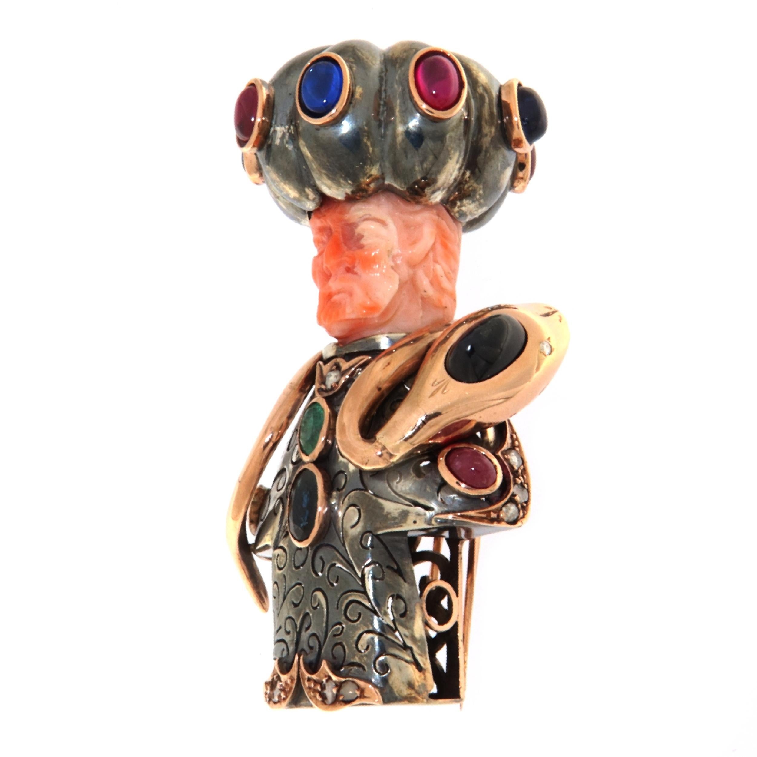 This unique brooch, expertly crafted in a blend of 18 and 9-karat yellow gold and sterling silver, is a true masterpiece of jewelry art that encapsulates stories of ancient times and heroic legends. At the heart of this exceptional piece is a coral