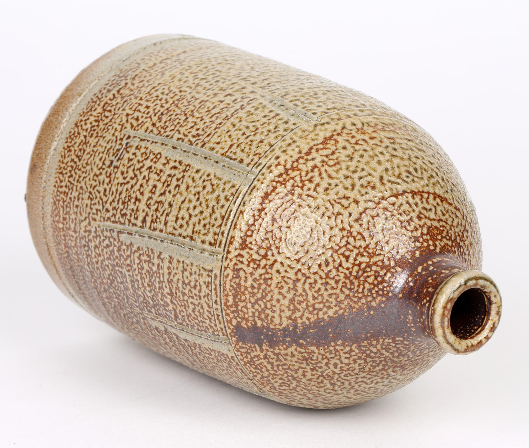 A very fine quality salt glazed studio pottery bottle flagon shaped vase by Dorset based potter Warwick Parker (b.1940) dating from the 20th century. The ceramic vase stands on a wide flat rounded base with a beehive shaped body with a short narrow