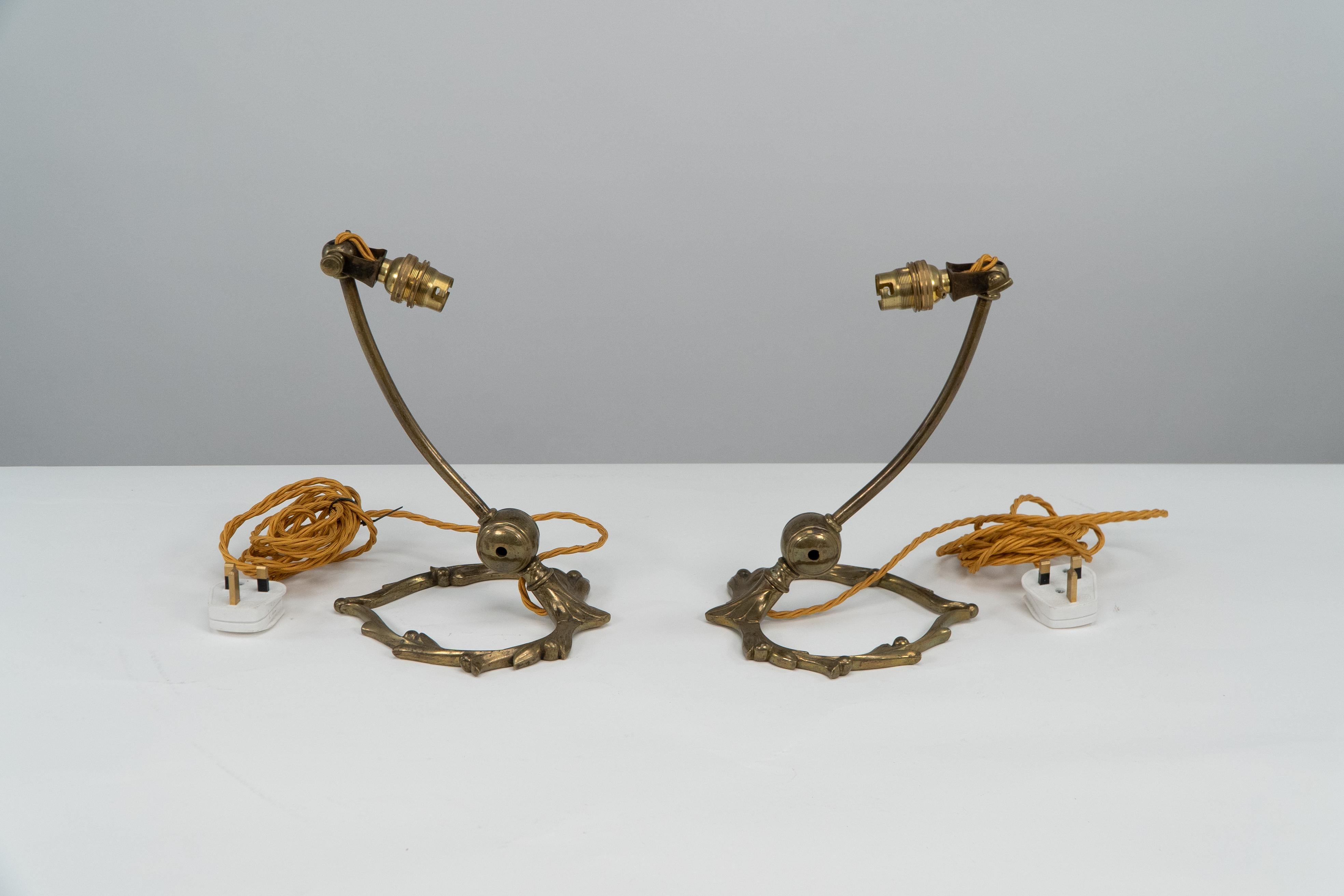 WAS Benson. Ein Paar verstellbare Tischlampen aus Messing im Arts-and-Crafts-Stil mit Misteldekoration auf der herzförmigen Basis. Preis für das Paar.
