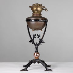 WAS Benson. An Arts and Crafts cast iron four leg table oil lamp