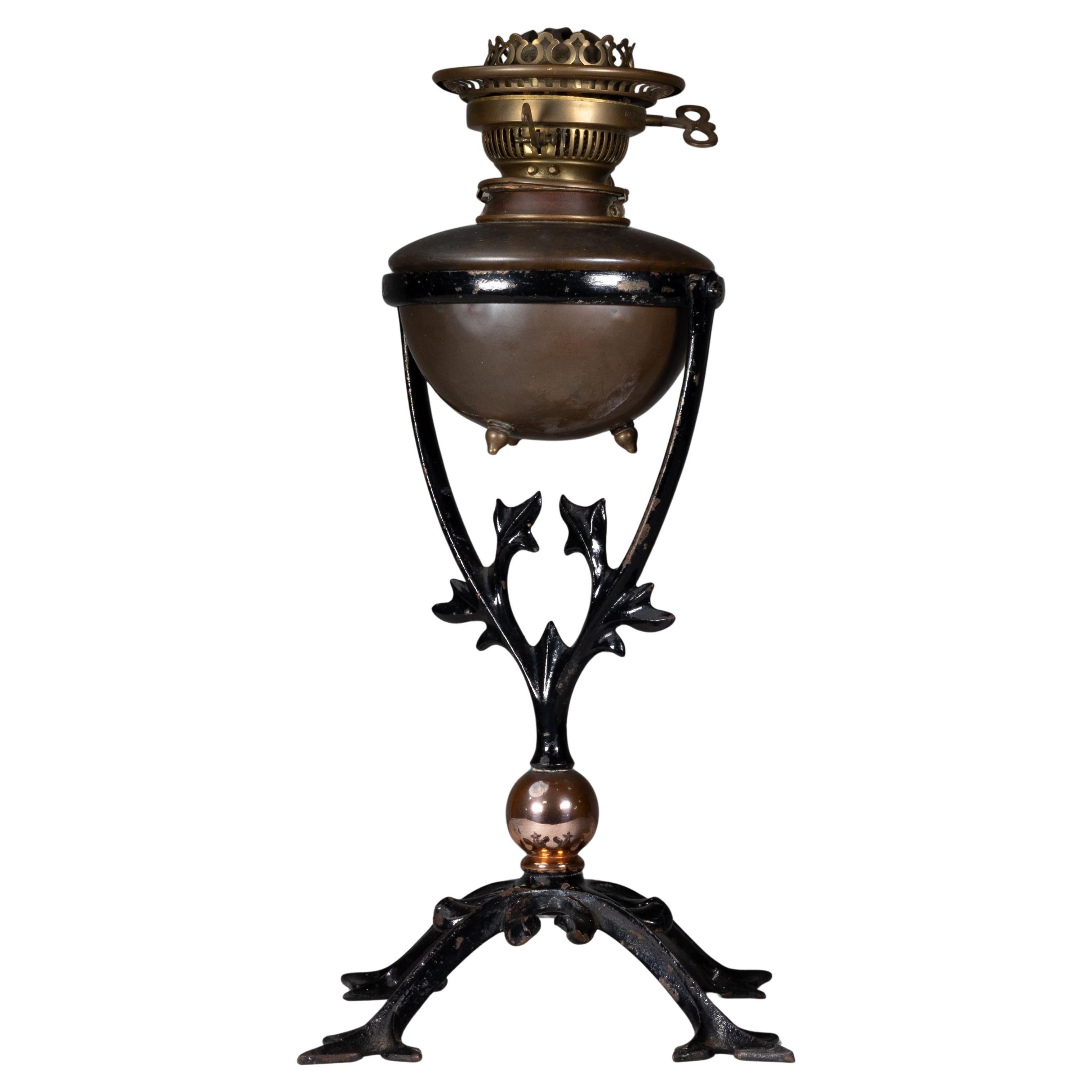 WAS Benson. An Arts and Crafts cast iron four leg table oil lamp