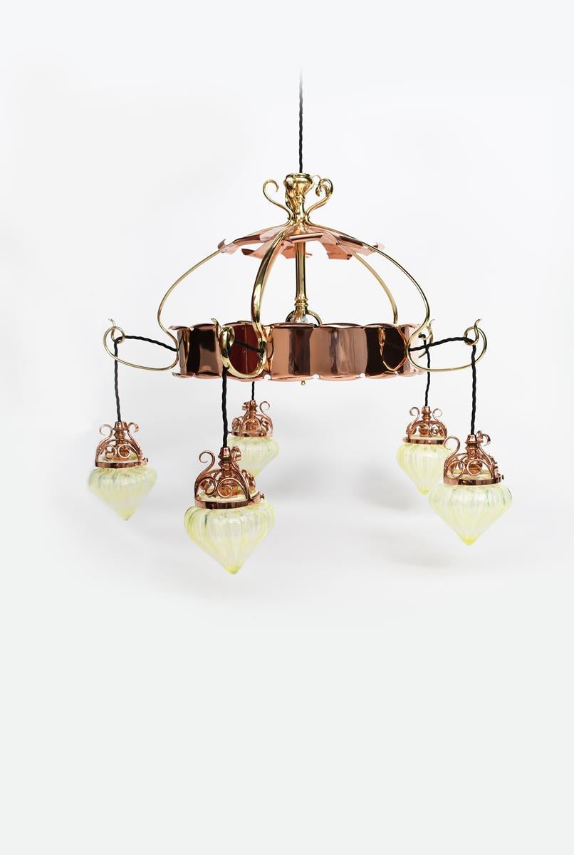 W.A.S Benson. 
A rare Arts & Crafts copper & brass five-branch chandelier with the original ceiling plate to the top and a turned support below, connecting to five whiplash arms with an upper decorative copper plate with scrolled edges, the whiplash