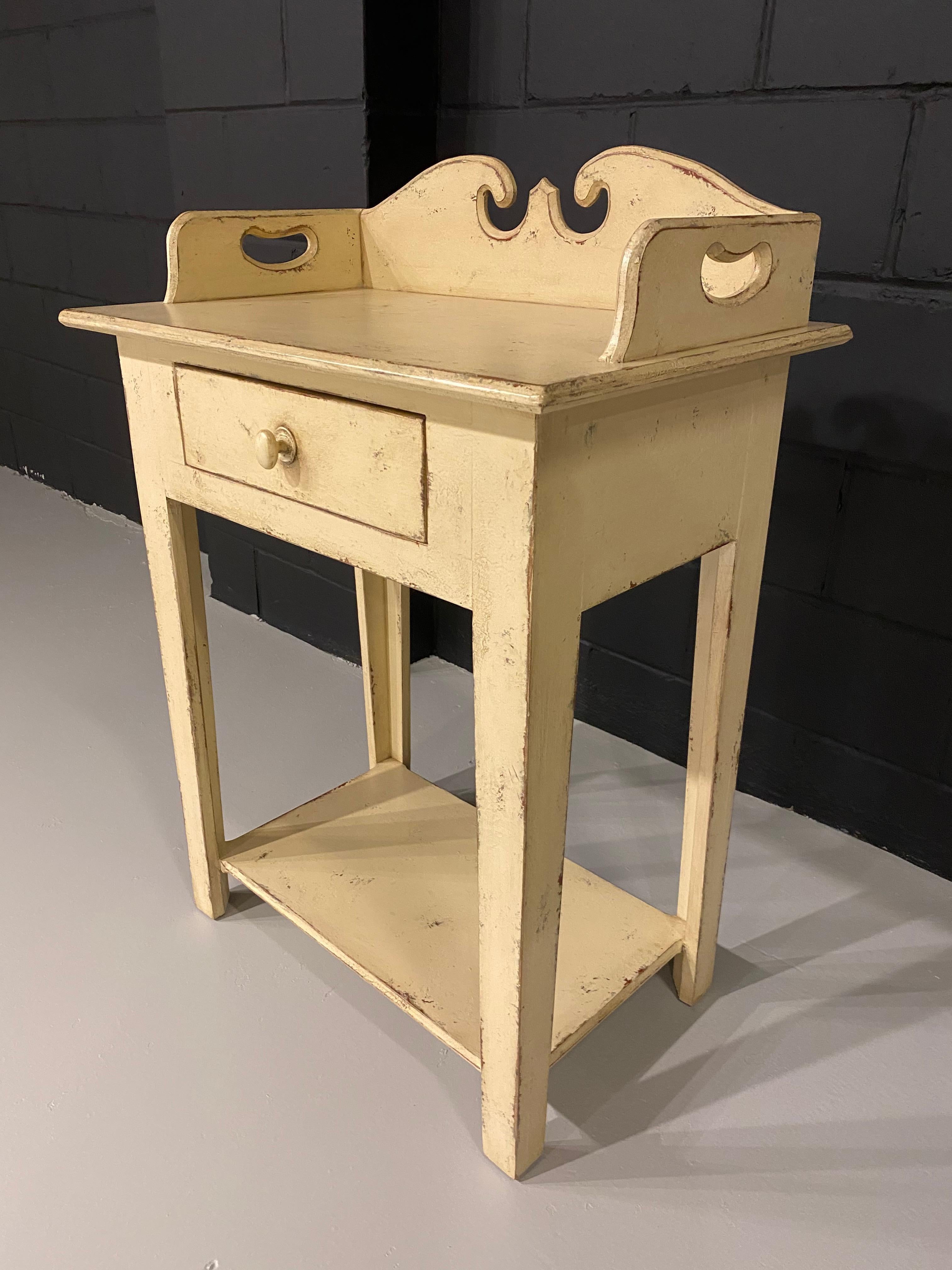 A pine wash stand made by Eddie West, with a vanilla color antique style paint finish. There is one drawer in this washstand.