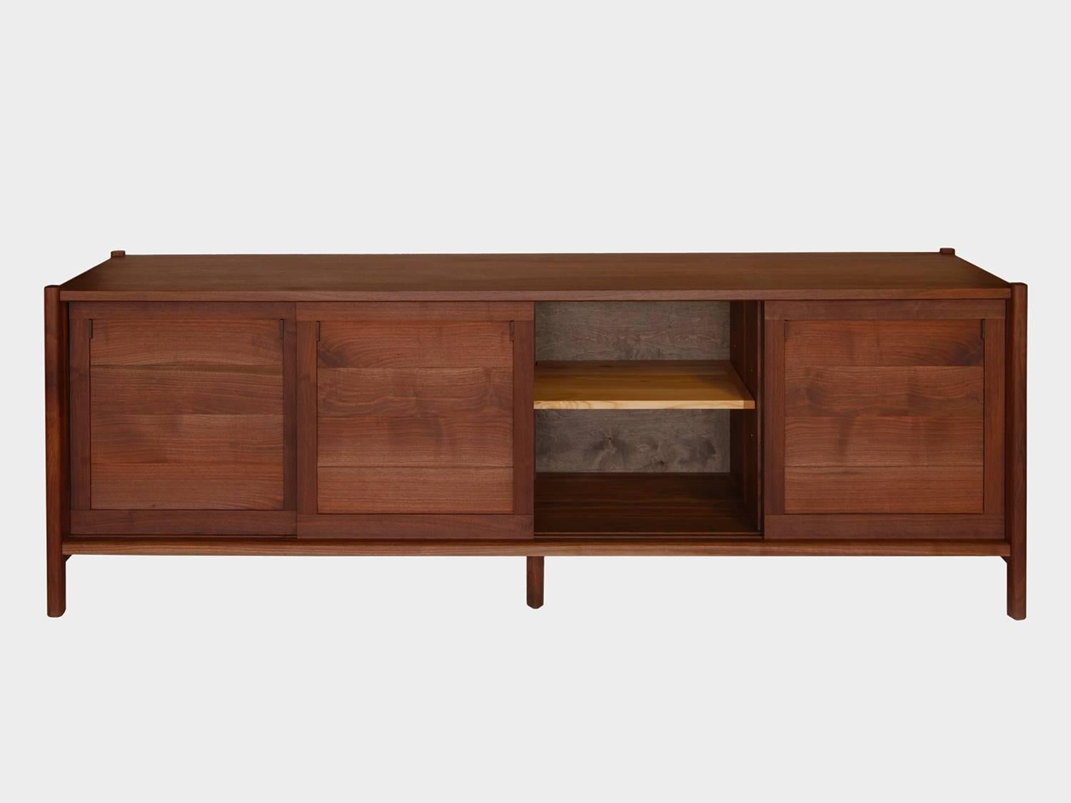 New York Heartwoods' contemporary black walnut credenza is influenced by Mid-Century Modern design and fabricated from solid wood, save the ebonized FSC plywood paneled back. Each cabinet has great storage capacity and is comprised of four artfully