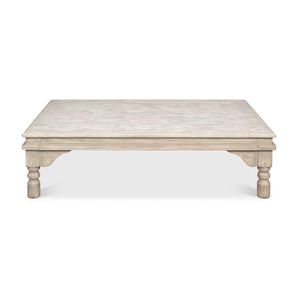 Bathed in a soft, washed gray painted finish, this table exudes a serene, welcoming vibe. Its substantial, low-rise design makes it a perfect anchor for your seating area, inviting leisurely conversations and cozy gatherings. The turned legs add a