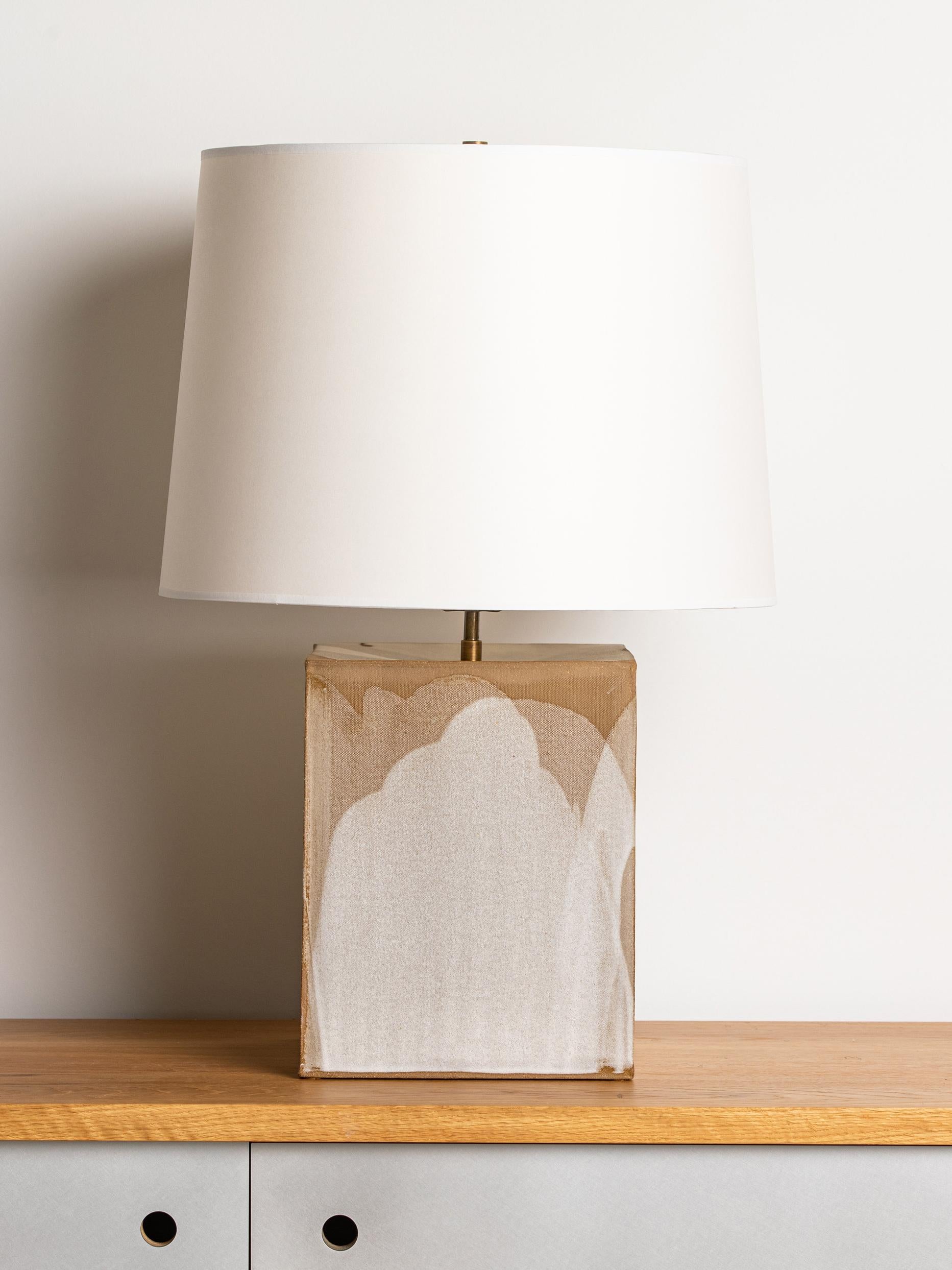 Our stoneware Washington Lamp is handcrafted using slab-construction techniques.

FINISH

- Poured glaze, pictured in parchment 
- Antique brass fittings
- Twisted black-cloth cord
- Full-range dimmer socket
- Off-white paper shade

BULB

75-watt
