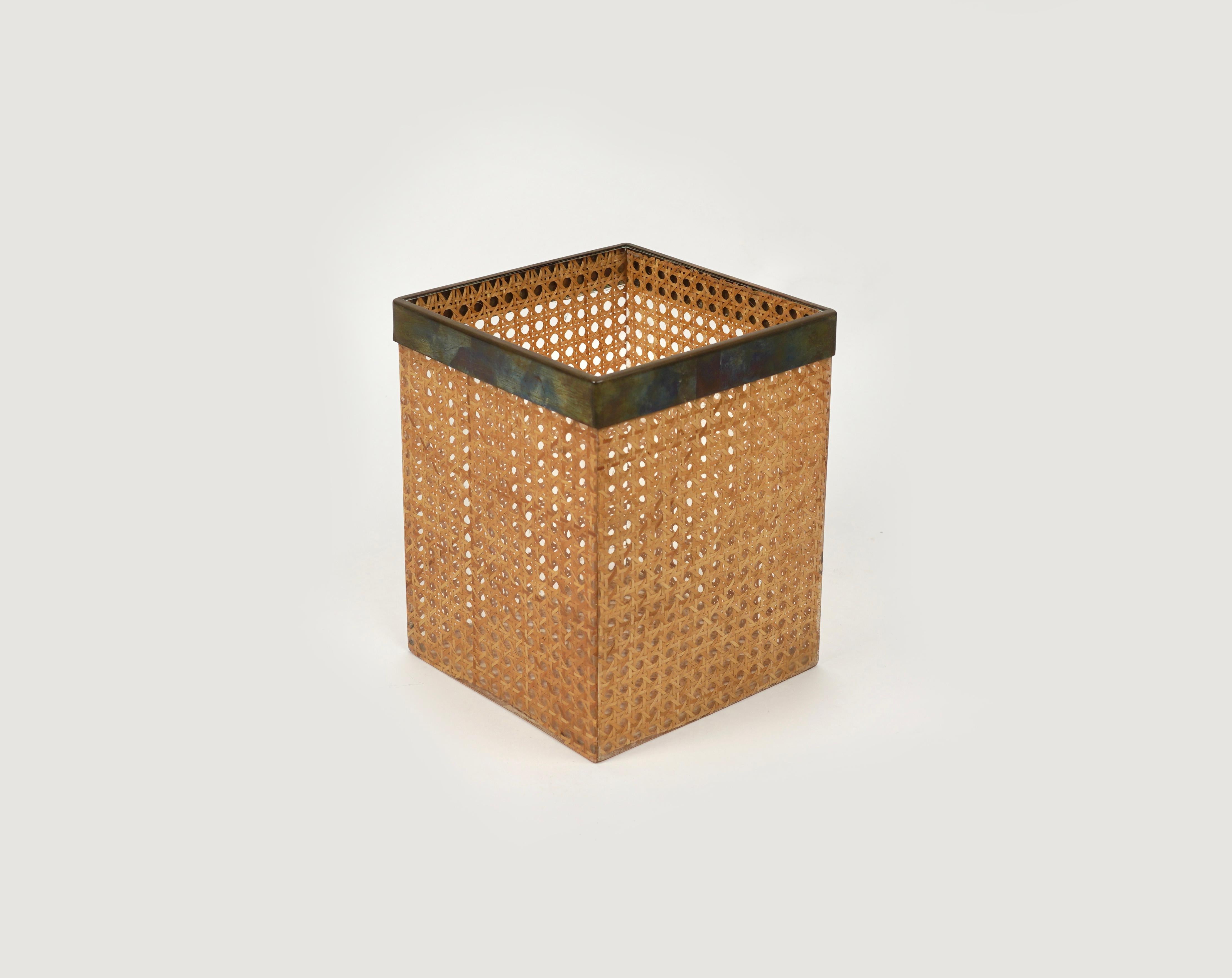 Mid-century basket waste paper bin in lucite and rattan with brass borders in the style of Christian Dior Home.

Made in Italy in the 1970s.