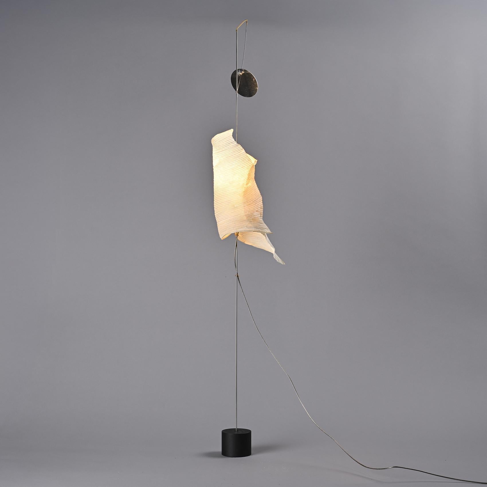
Wata Punga table lamp designed by Ingo Maurer for his MaMo Nouchies line, circa 1998. 

Japanese paper shade carefully pleated and sculpted, suspended from a light wire structure resting on a subtle base. Light filters through the pleats, and the