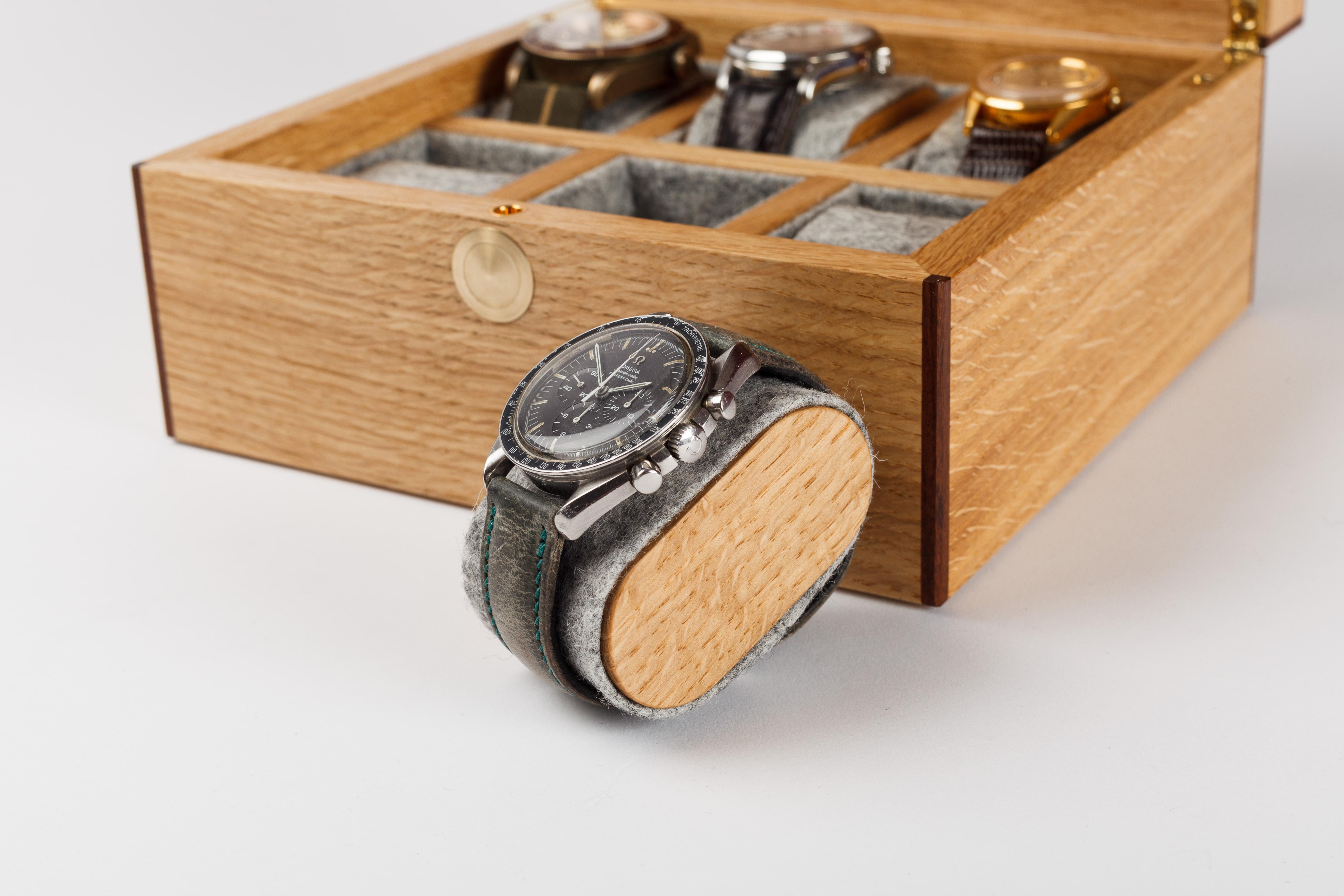 6 Watch box in Scottish oak, with veneered oak burl lid. The box is finished with solid rosewood edge banding and beautifully figured book-matched walnut on the underside of the lid. The individual watch compartments are lined in 100% wool felt and