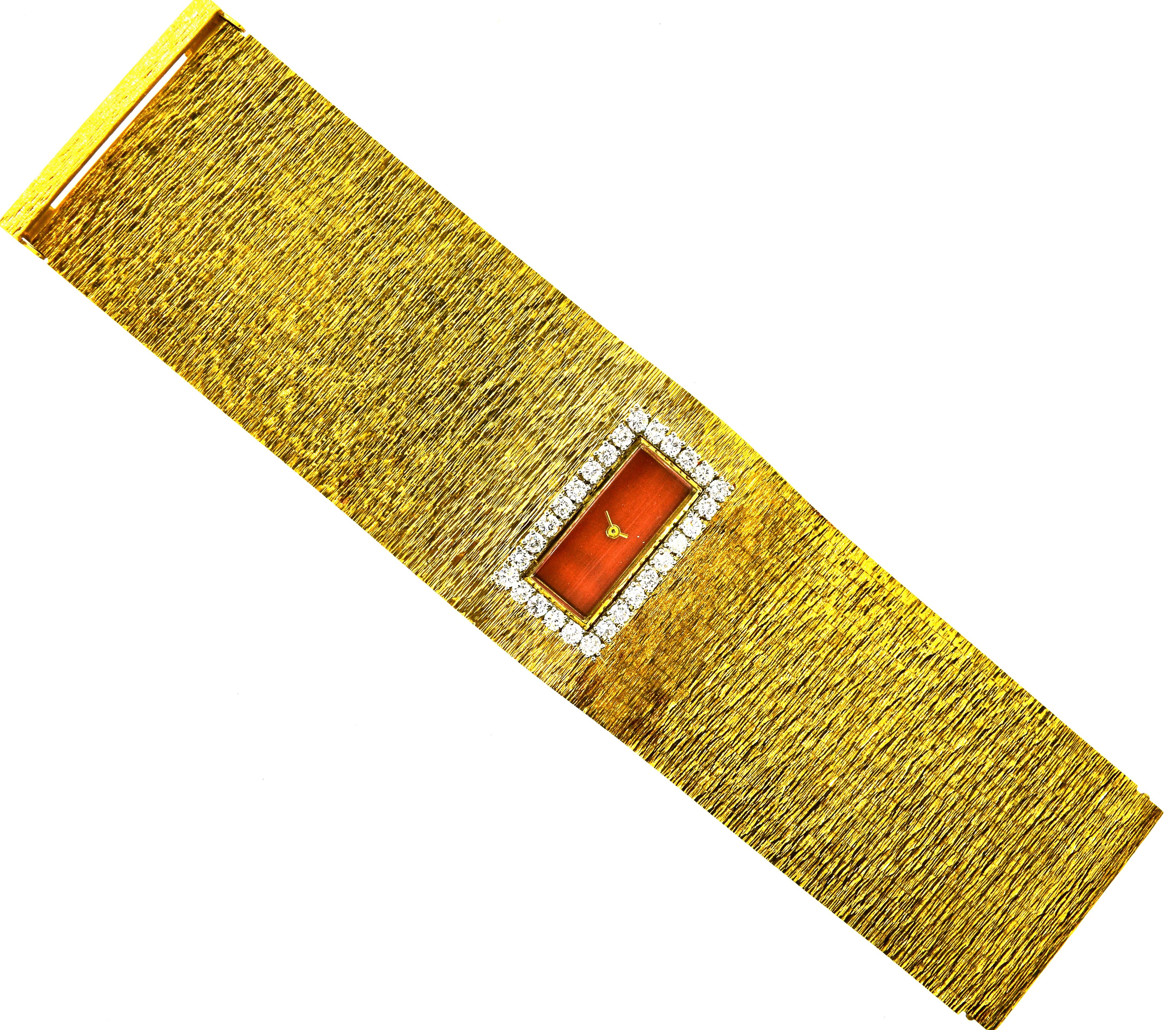 Bracelet with diamonds and a center watch by the London firm Milner.  This piece is a wide and bold  statement of bright gold and diamonds with a center coral dial watch.  This watch-bracelet is a bright yellow gold statement, it is 9K (marked 375).