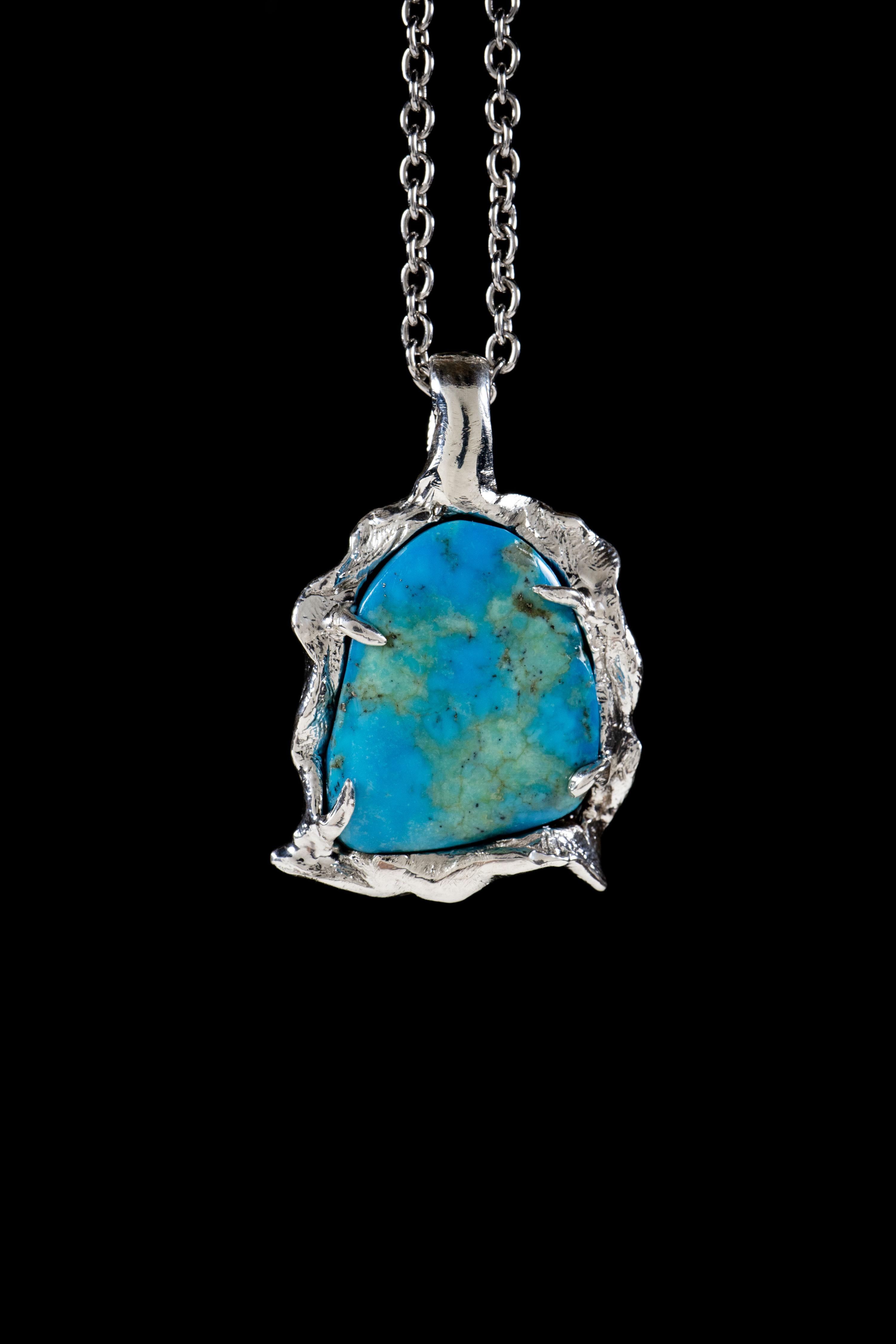 Water is a handmade pendant by Ken Fury, carved and cast in sterling silver with a beautiful turquoise stone. The sculptural design of the pendant symbolizes the fluid and ever-changing nature of life, while the turquoise stone represents healing,