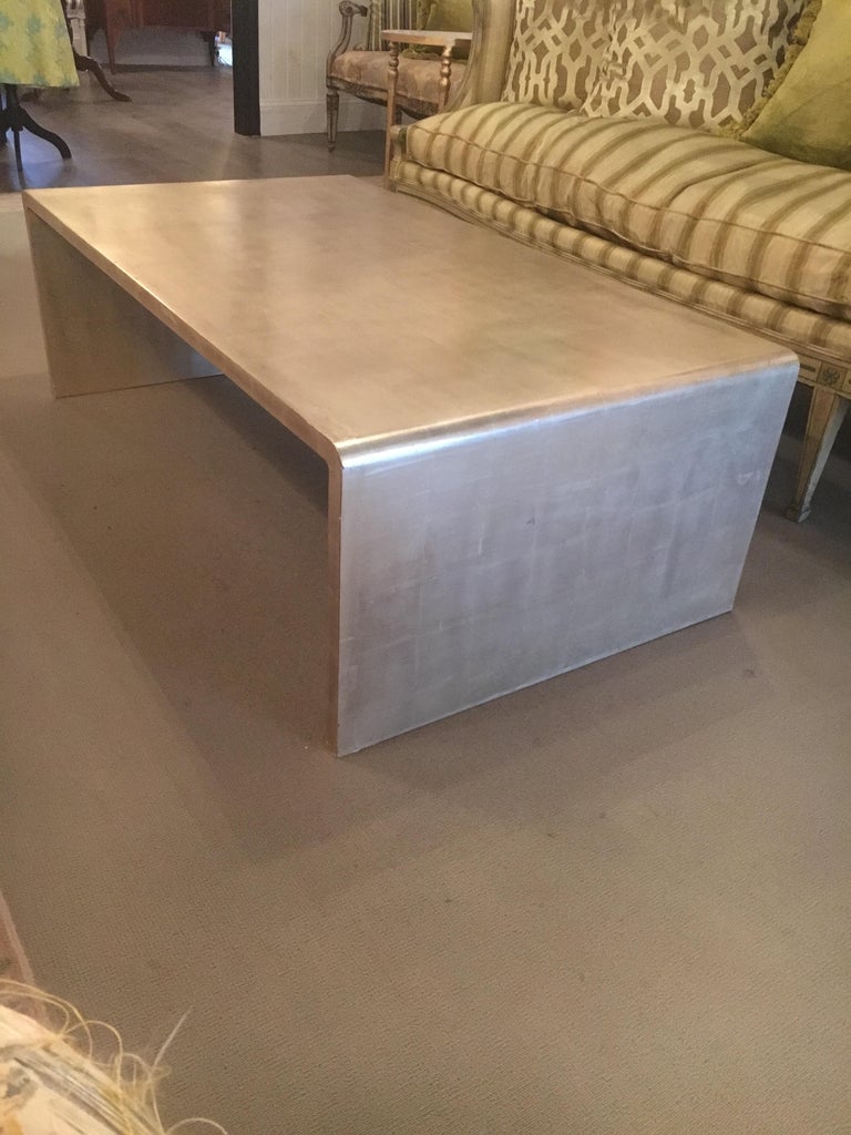 Very chic waterfall coffee table with silver leaf finish. Great size and proportions.