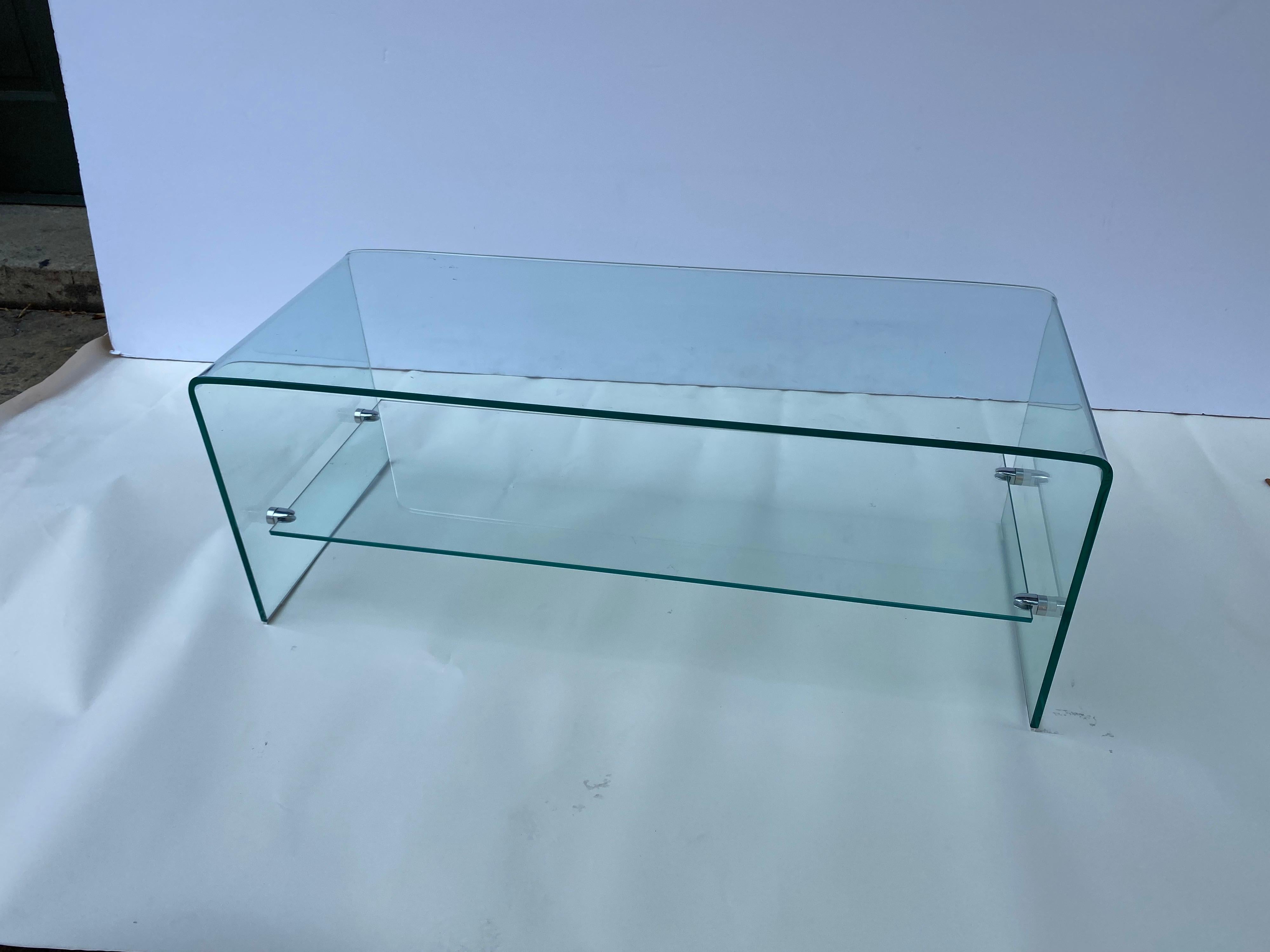 Nice scale and size waterfall glass coffee table with lower shelf. Nice sleek design, perfect for smaller spaces or next to a window!