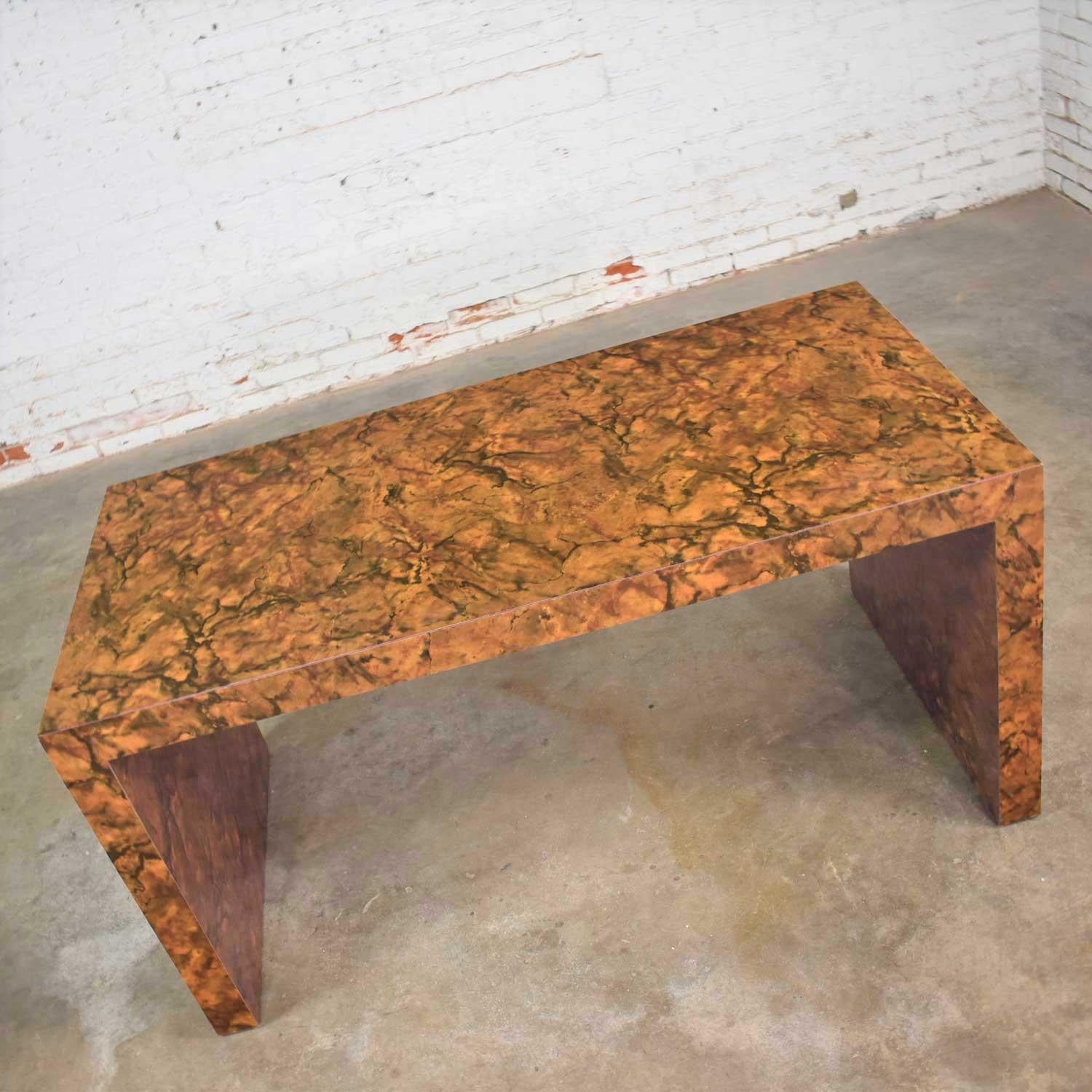 Handsome modern table, console table, or desk in a waterfall parsons styling covered in a faux tortoise shell laminate and made in the design style of Karl Springer. It is in wonderful vintage condition. It does have a small repair to the laminate