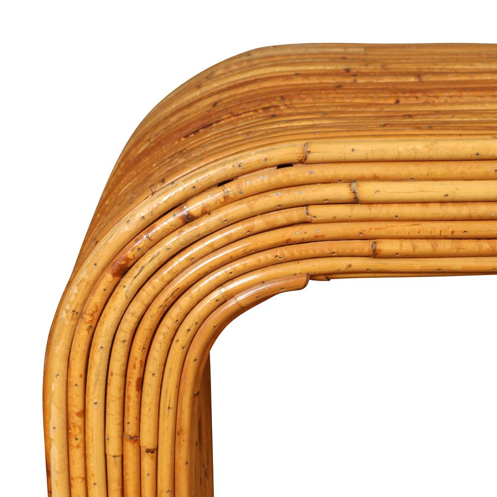 A striking console composed of pencil reed bamboo in the form of a waterfall with curved sides.  Although like and sleek in appearance, this interesting table is sturdy and well constructed.  It has developed a rich, warm patina and would add