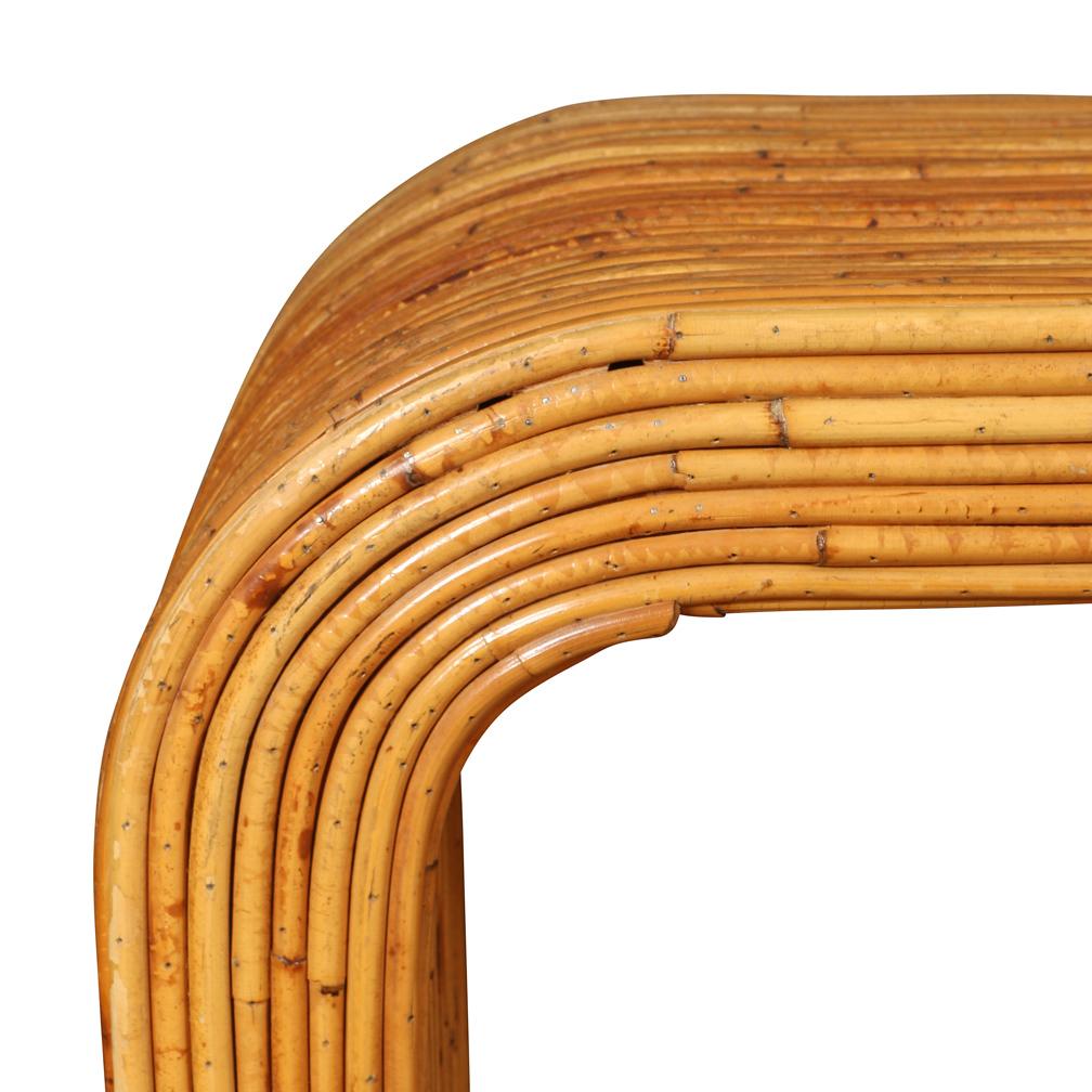 Una llamativa consola compuesta de cañas de bambú en forma de cascada con los lados curvados.  Aunque de aspecto elegante, esta interesante mesa es robusta y está bien construida.  Ha desarrollado una pátina rica y cálida y añadiría interés a